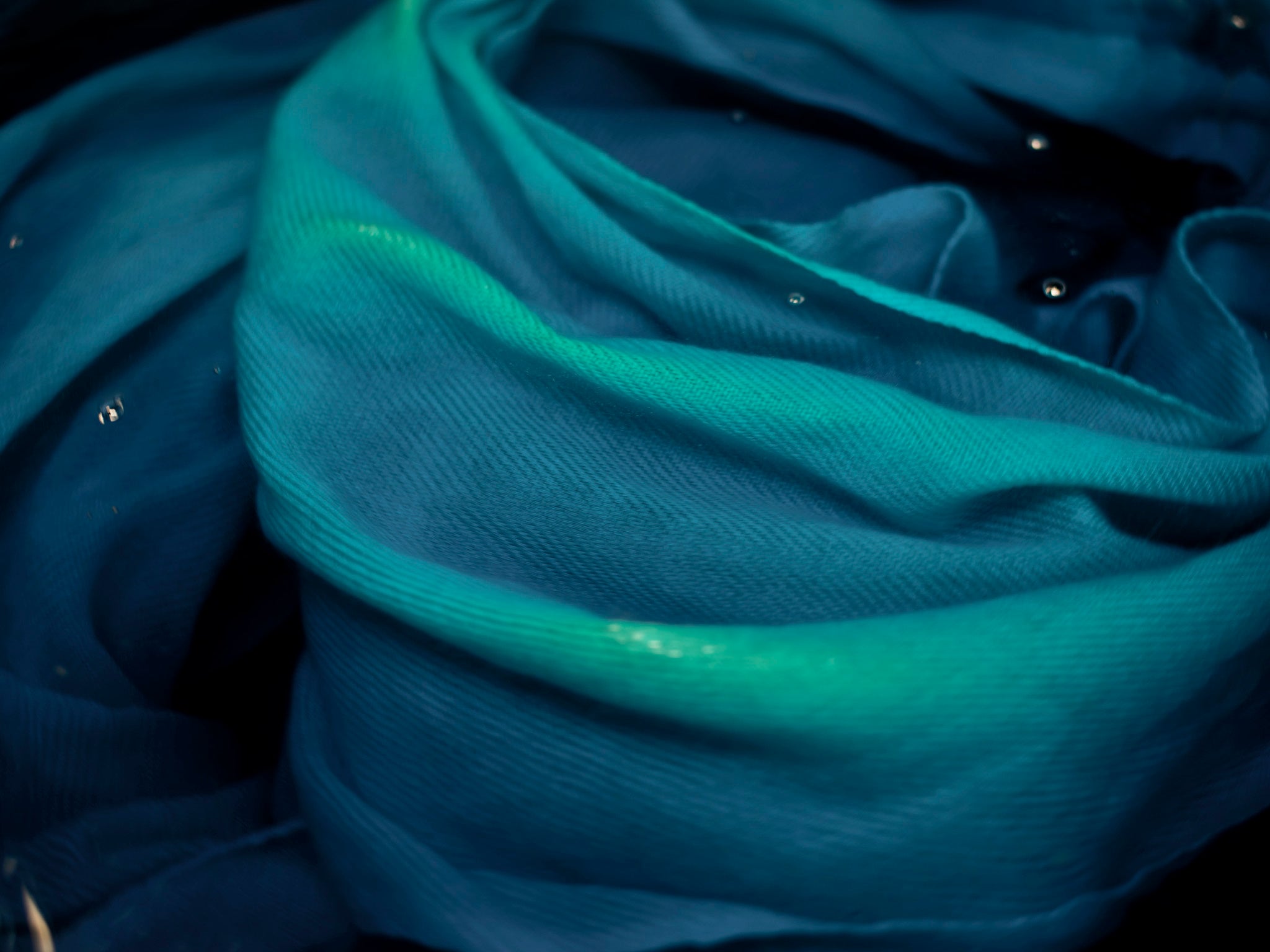 A cashmere shawl is submerged into a colour dye at the workshop in Kathmandu