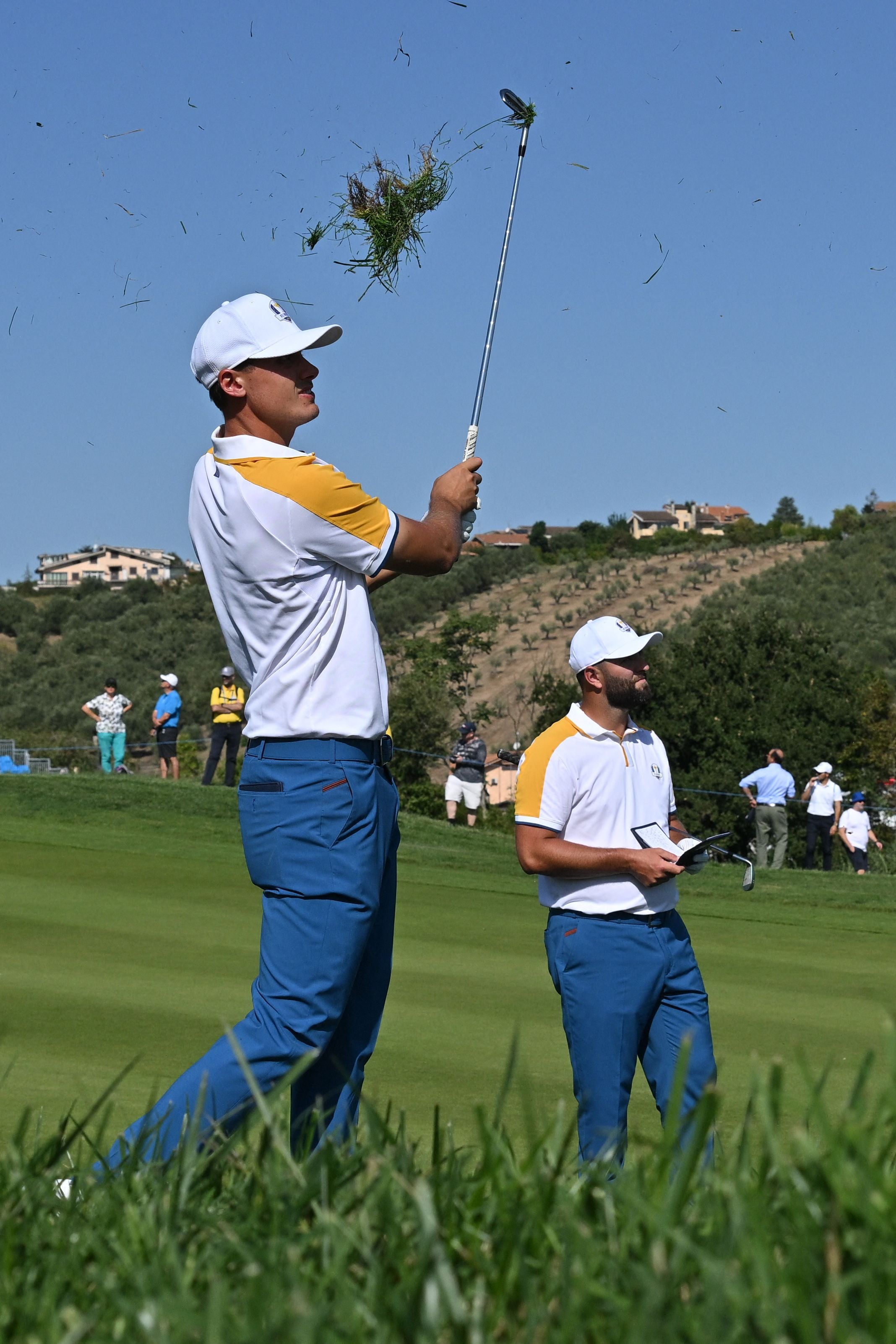 Europe’s Ludvig Aberg pulls up a clump of grass as he practices from the rough