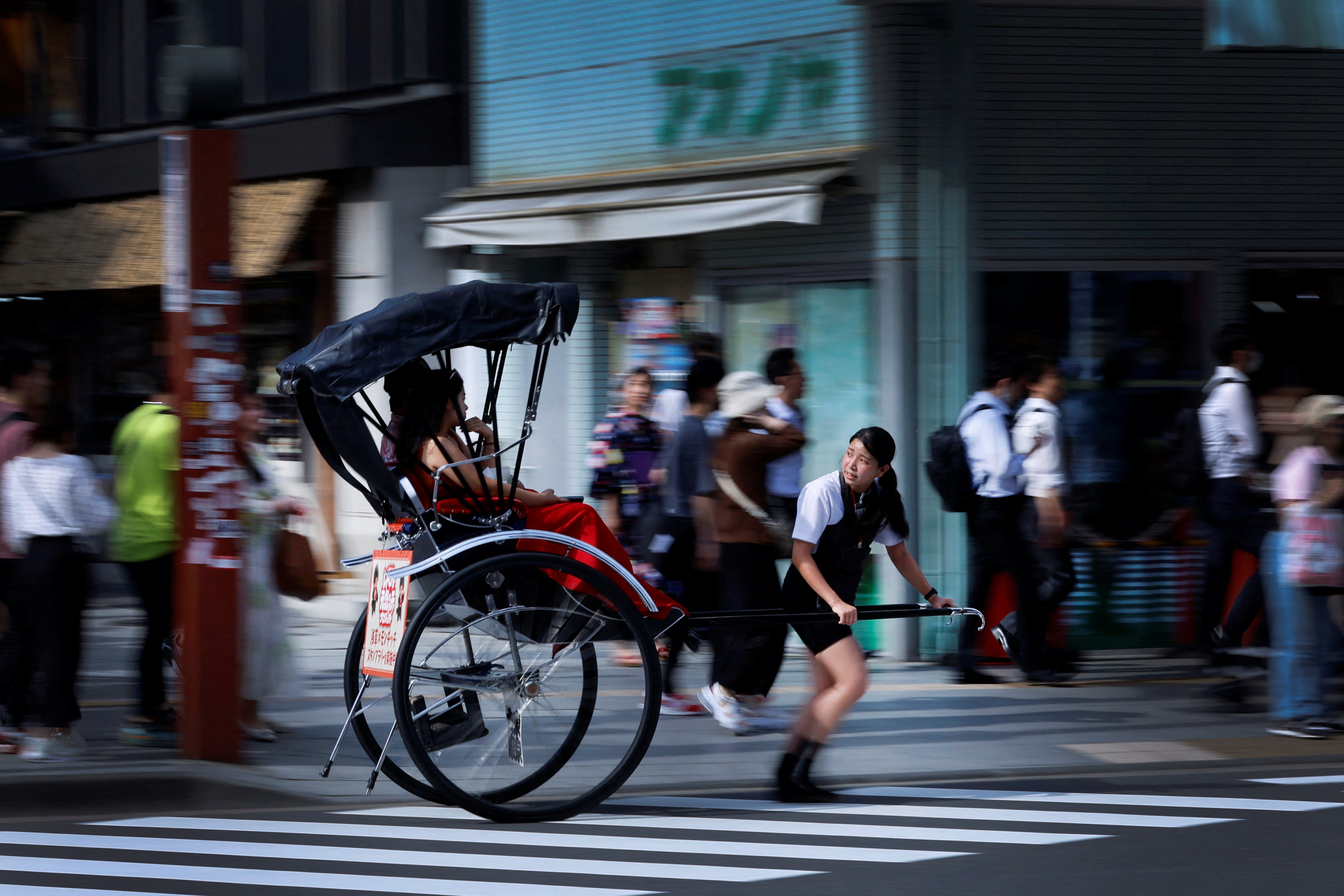 Akina Suzuki, 19, pulls a rickshaw around Asakusa district in Tokyo