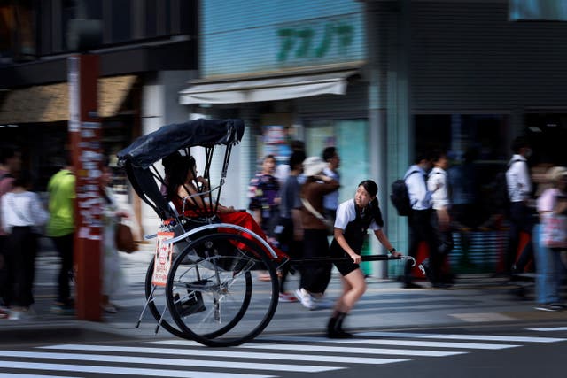 <p>Akina Suzuki, 19, pulls a rickshaw around Asakusa district in Tokyo</p>