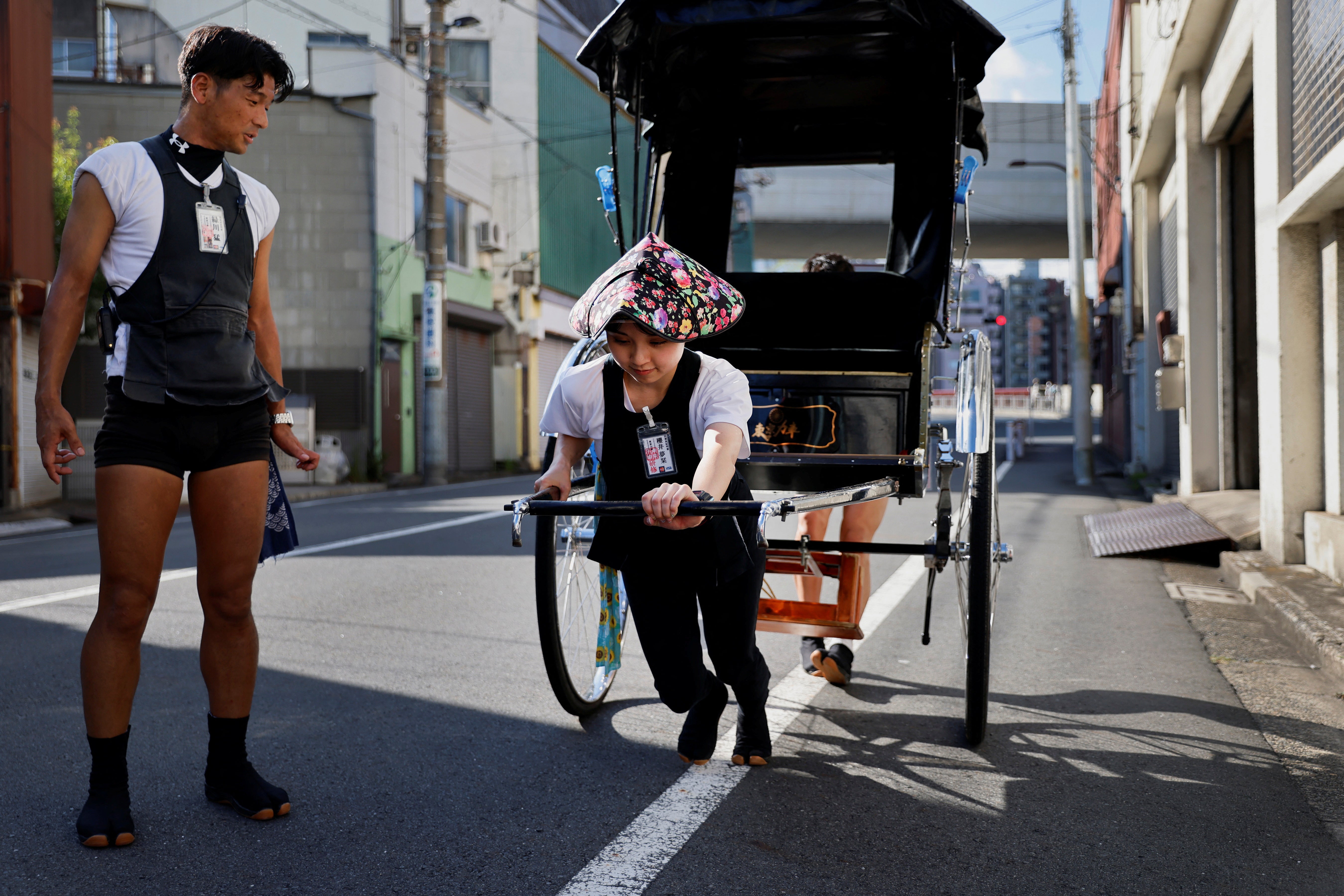 Trainee Yumeka Sakurai receives rickshaw lessons from a colleague
