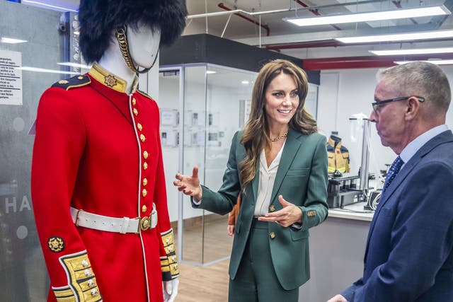 The Princess of Wales looks at a guardsman’s scarlet tunic during a visit to AW Hainsworth in Leeds (Danny Lawson/PA)