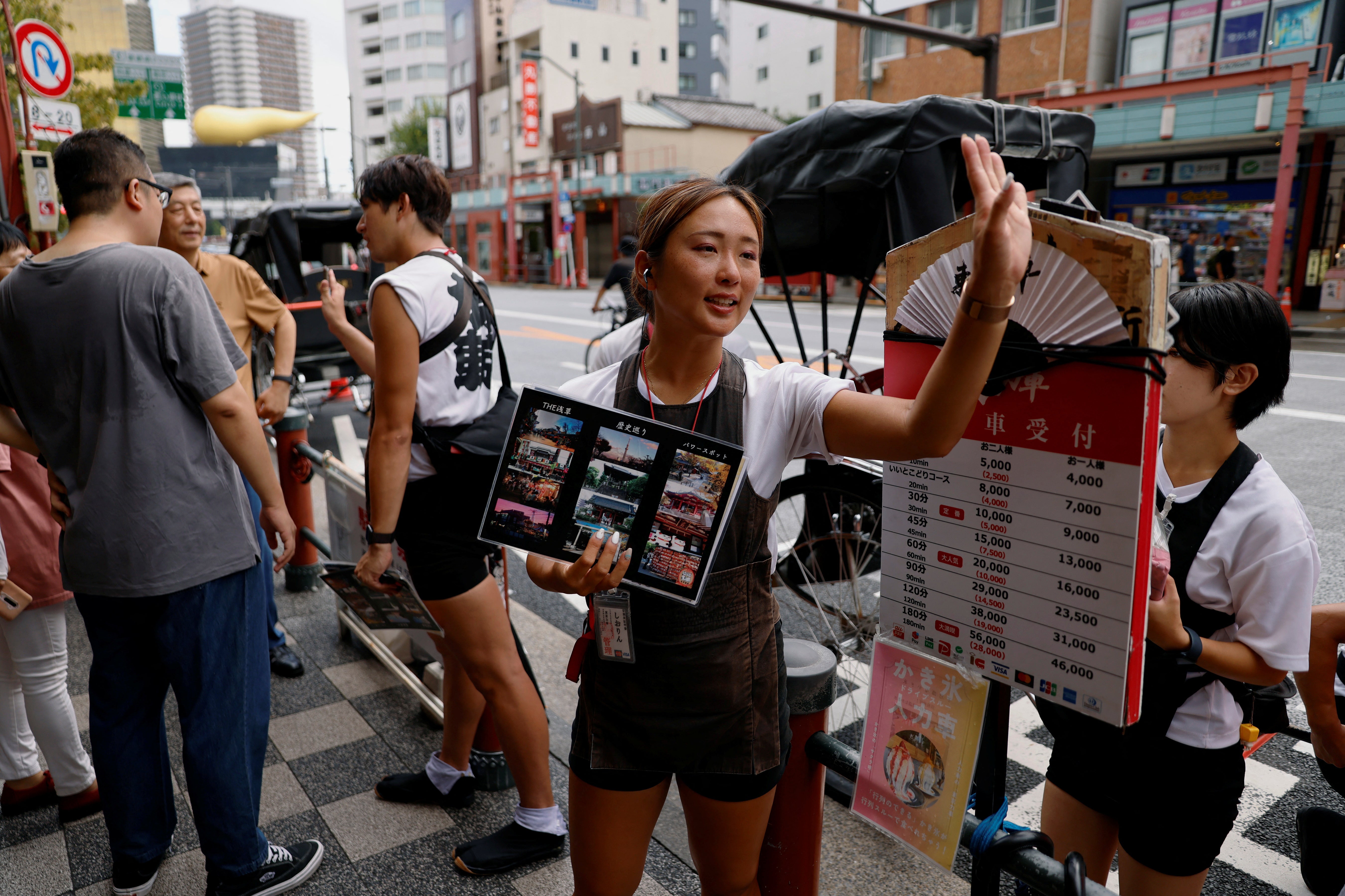 Rickshaw puller Shiori Yoshida, 28, attracts tourists to a guided tour in Asakusa