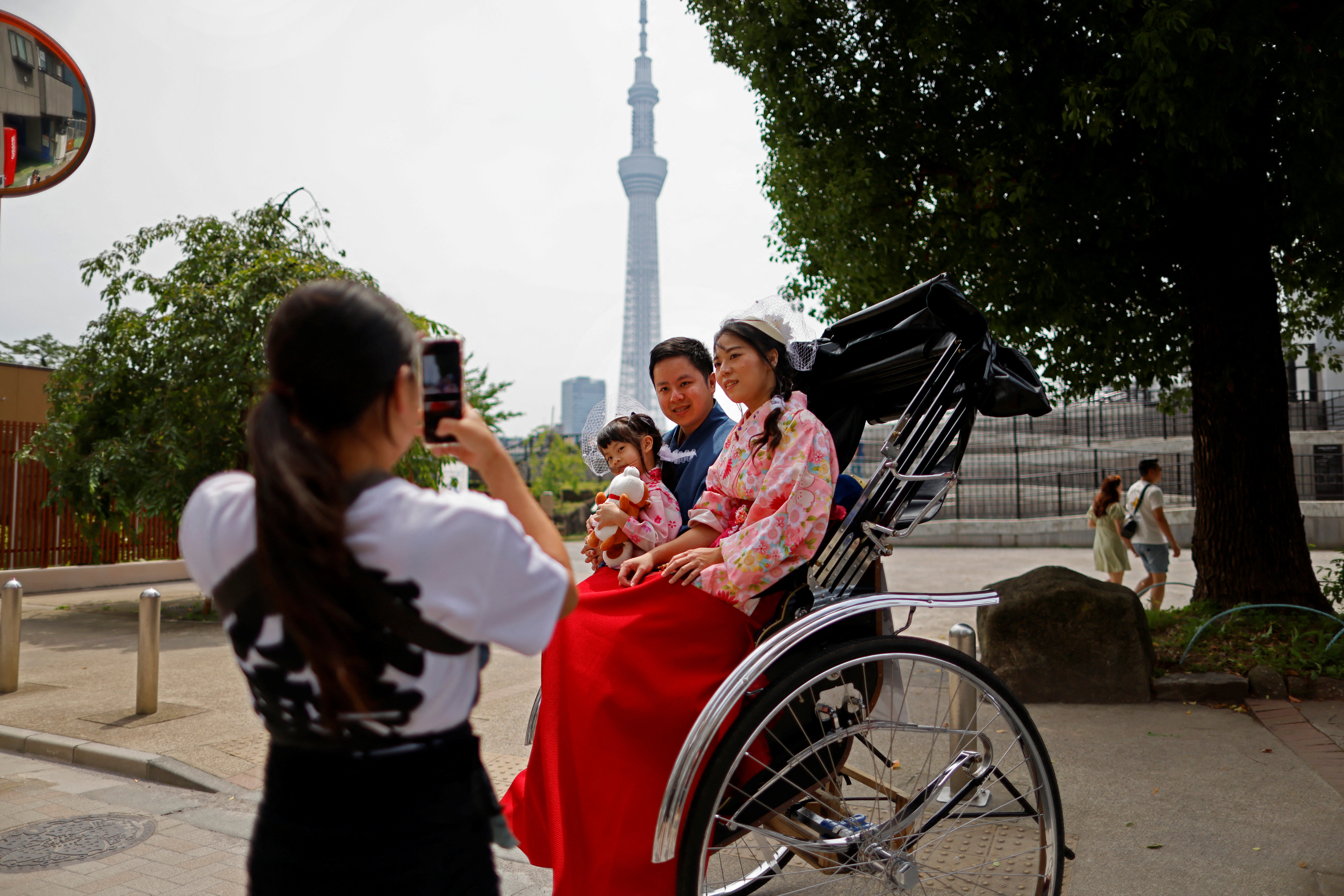 Akina Suzuki, 19, takes a photo of a Taiwanese family during her tour