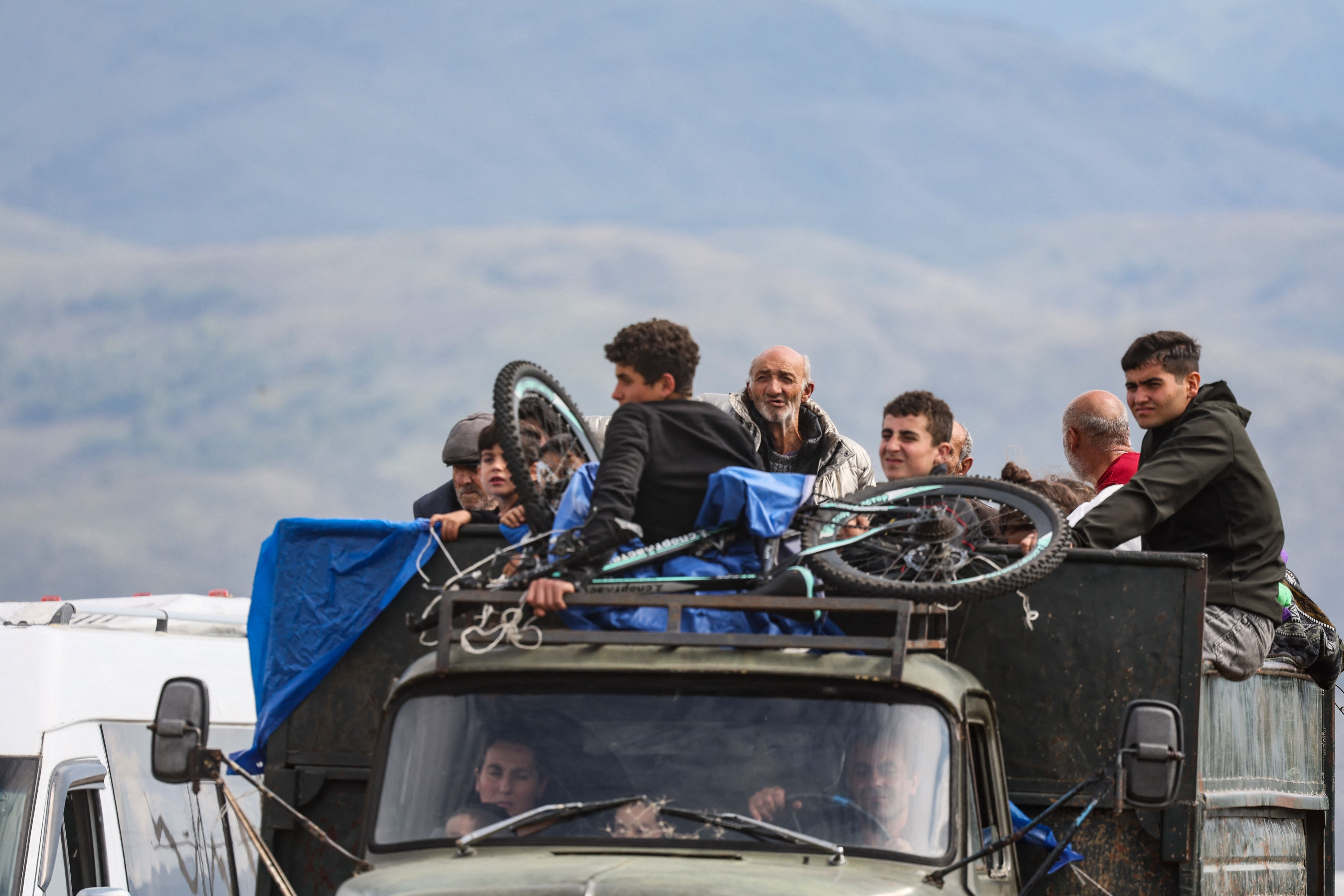 Refugees sit in a truck near the town of Kornidzor, Armenia on Tuesday