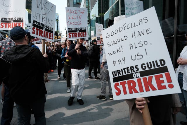 <p> Members of the Writers Guild of America (WGA) East hold signs as they walk in the picket-line outside of HBO and Amazon’s offices on 10 May 2023 in New York City</p>