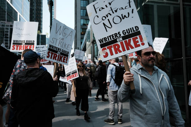 Members of the Writers Guild of America (WGA) East hold signs as they walk in the picket-line outside of HBO and Amazon’s offices on 10 May 2023