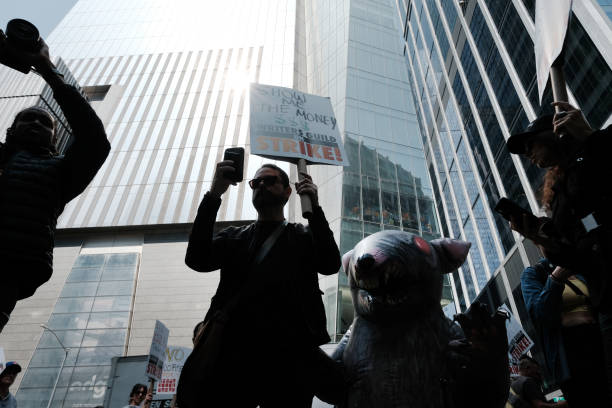 Members of the Writers Guild of America (WGA) East hold signs as they walk in the picket-line outside of HBO and Amazon’s offices on 10 May 2023