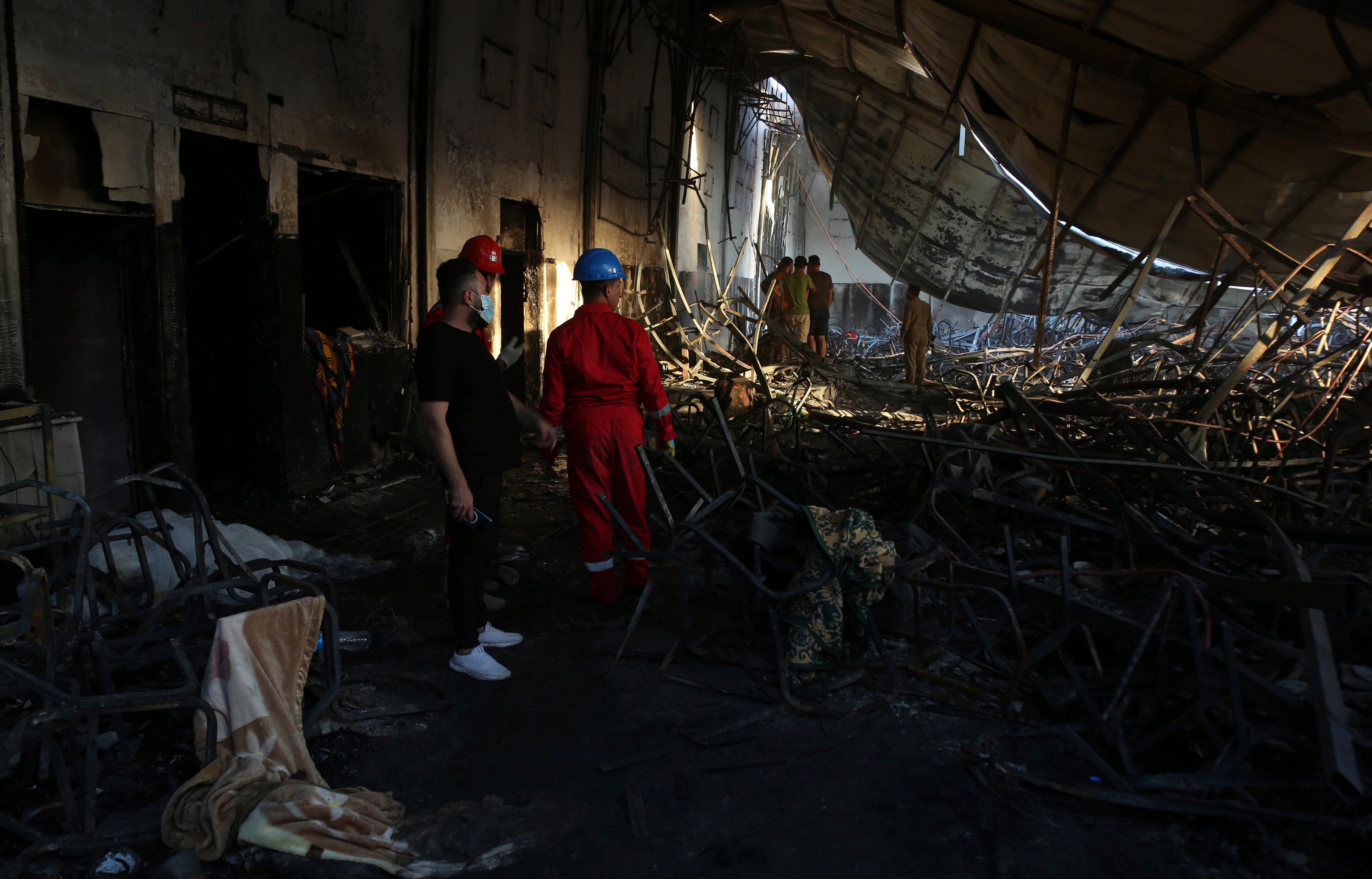 Firefighters work at the site of a fatal fire, in the district of Hamdaniya, Nineveh province, Iraq, Wednesday, 27 September2023