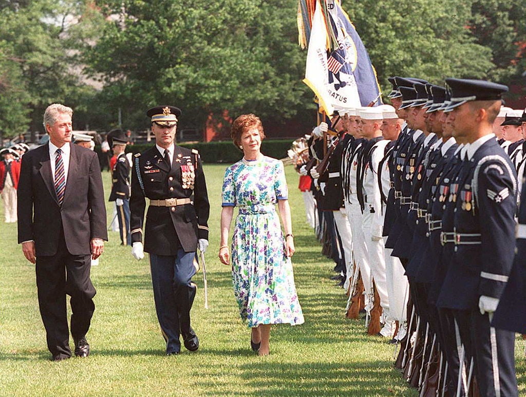 US President Bill Clinton and Irish President Mary Robinson walk alongside a US military honor guard with US Army Major General Robert Foley at Fort Myer, Virginia, in June 1996