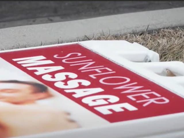 <p>A sign for Sunflower Massage in American Fork, Utah, lying on the ground after police raided the business on suspicion that illegal sex services were being offered by workers</p>
