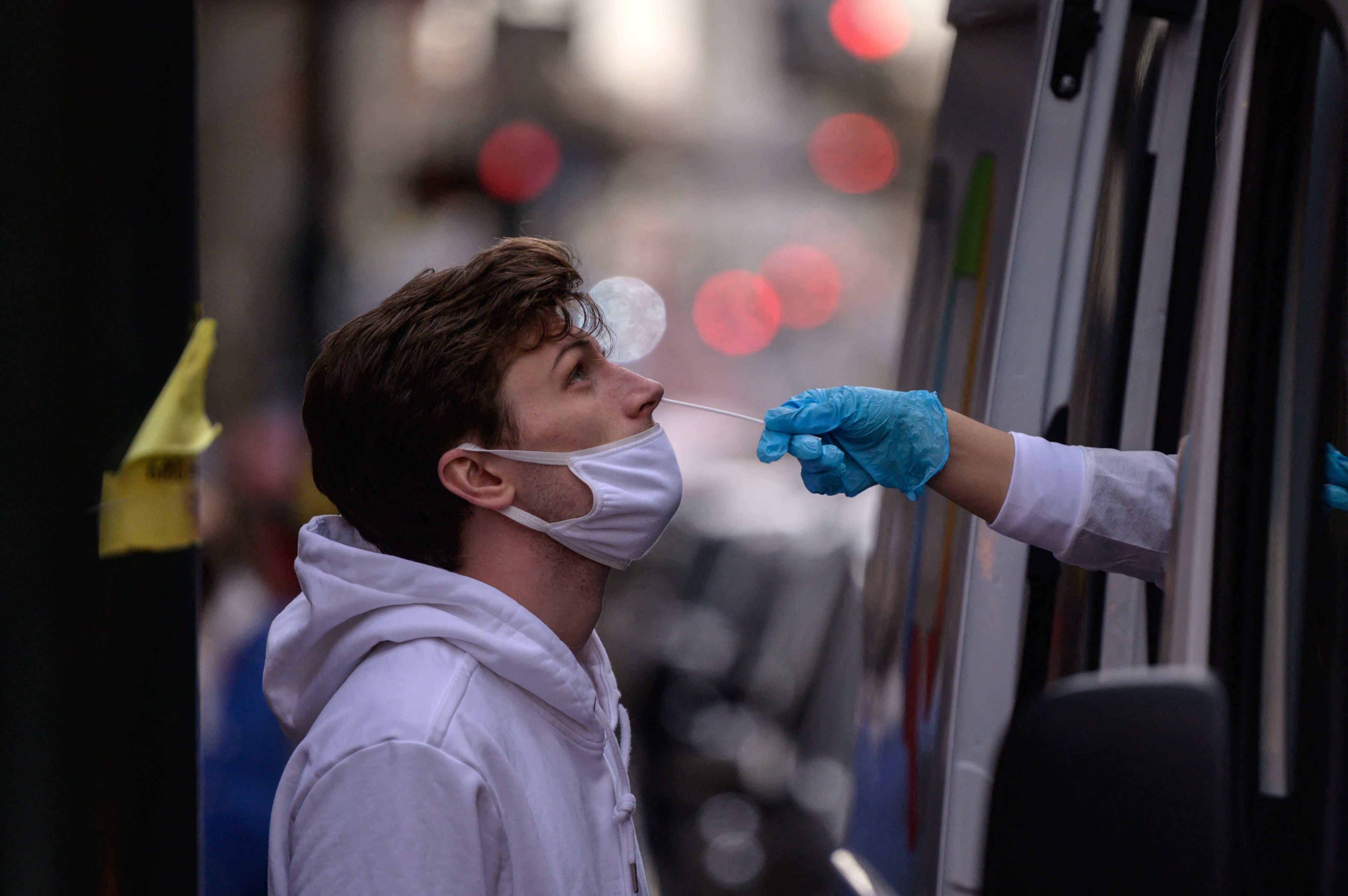 A man receives a nasal swab during a test for Covid-19 at a street-side testing booth in New York on December 17, 2021