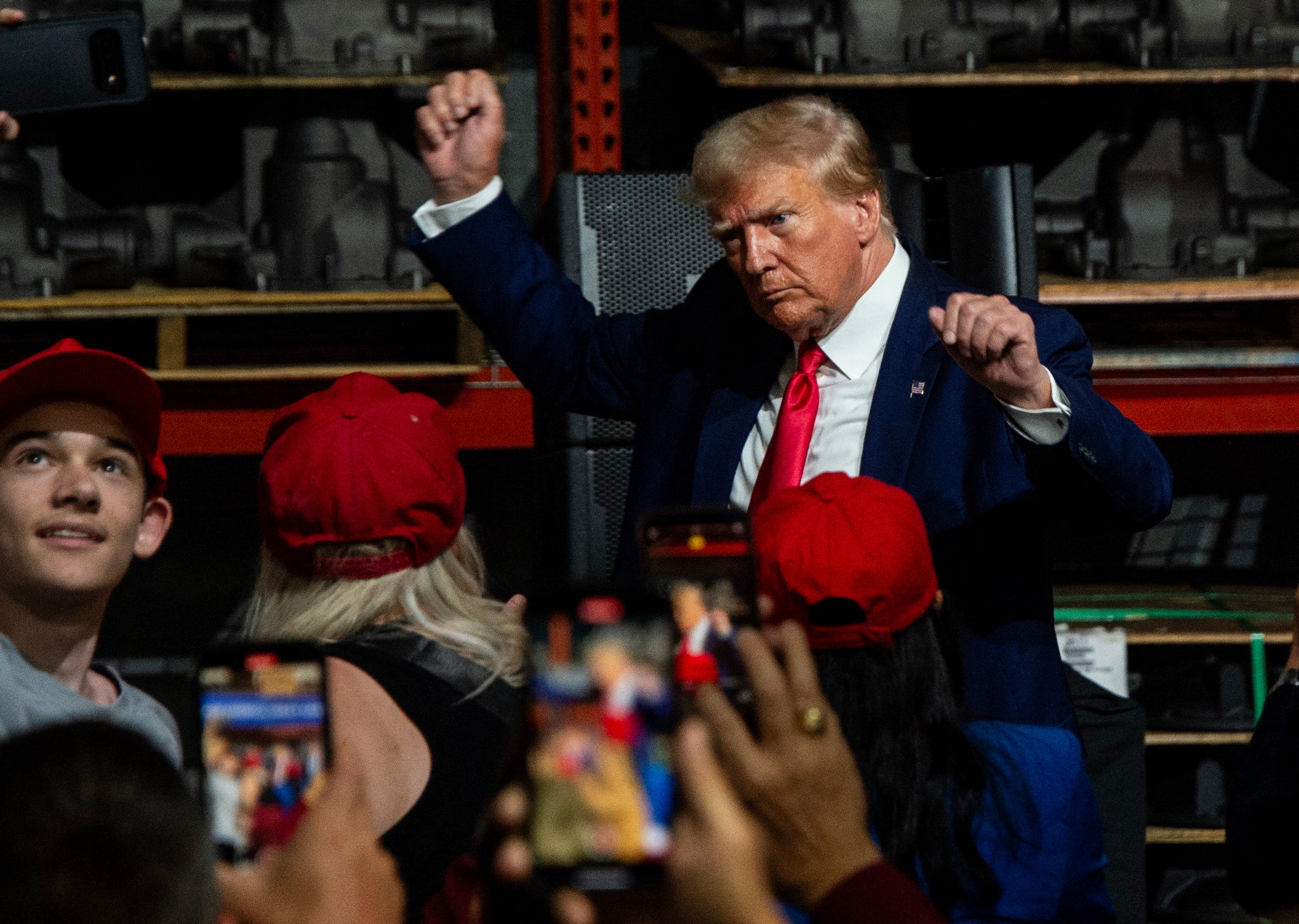 Former US President and 2024 presidential hopeful Donald Trump gestures while speaking at Drake Enterprises, an automotive parts manufacturer and supplier, in Clinton, Michigan