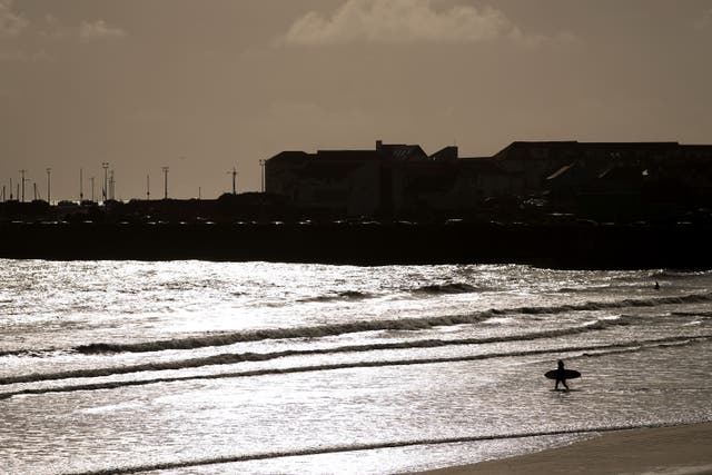 Surfers at Sandy Bay in Porthcawl, Wales (Joe Giddens/PA)