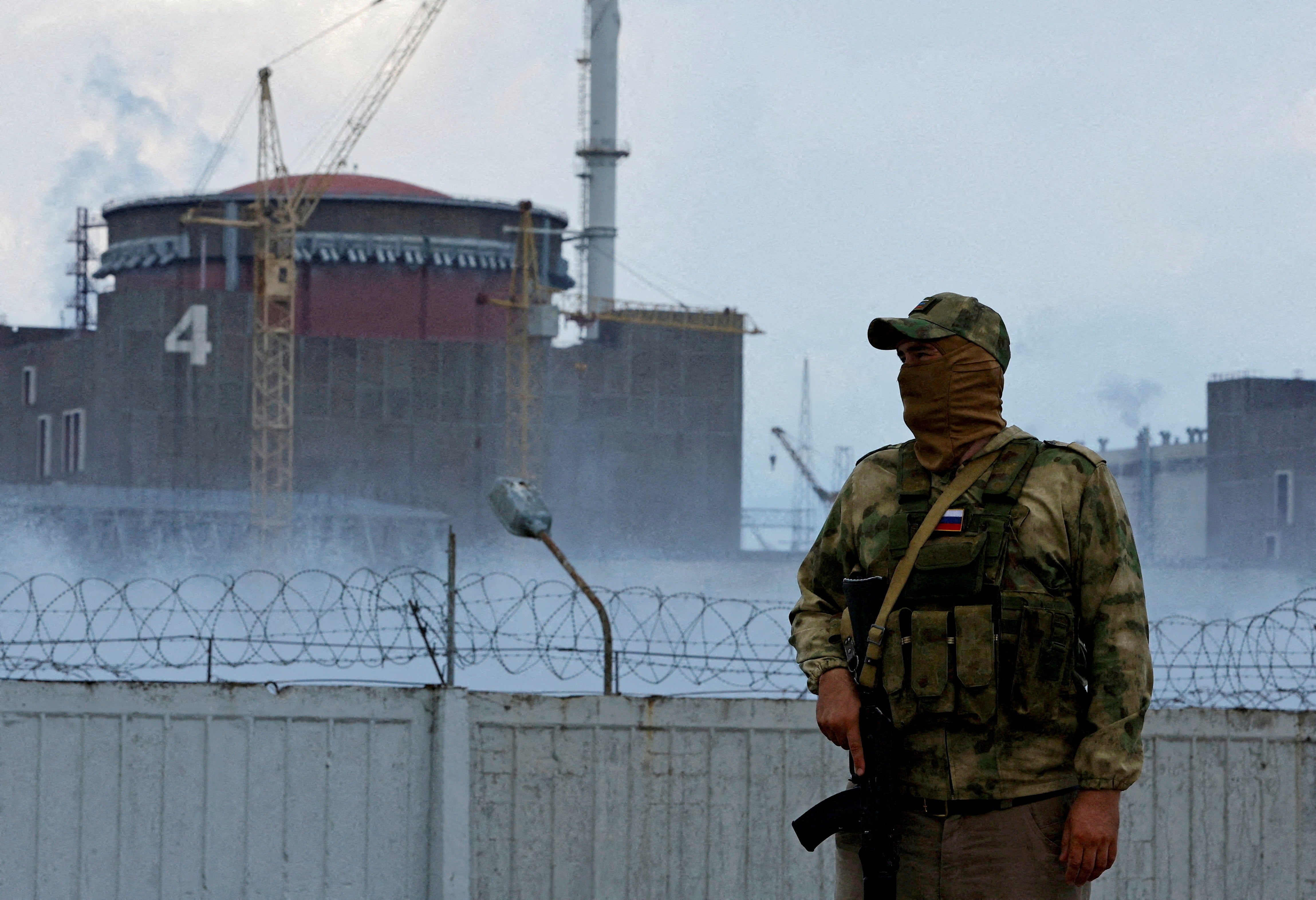 A Russian soldier stands guard outside the Zaporizhzhia Nuclear Power Plant