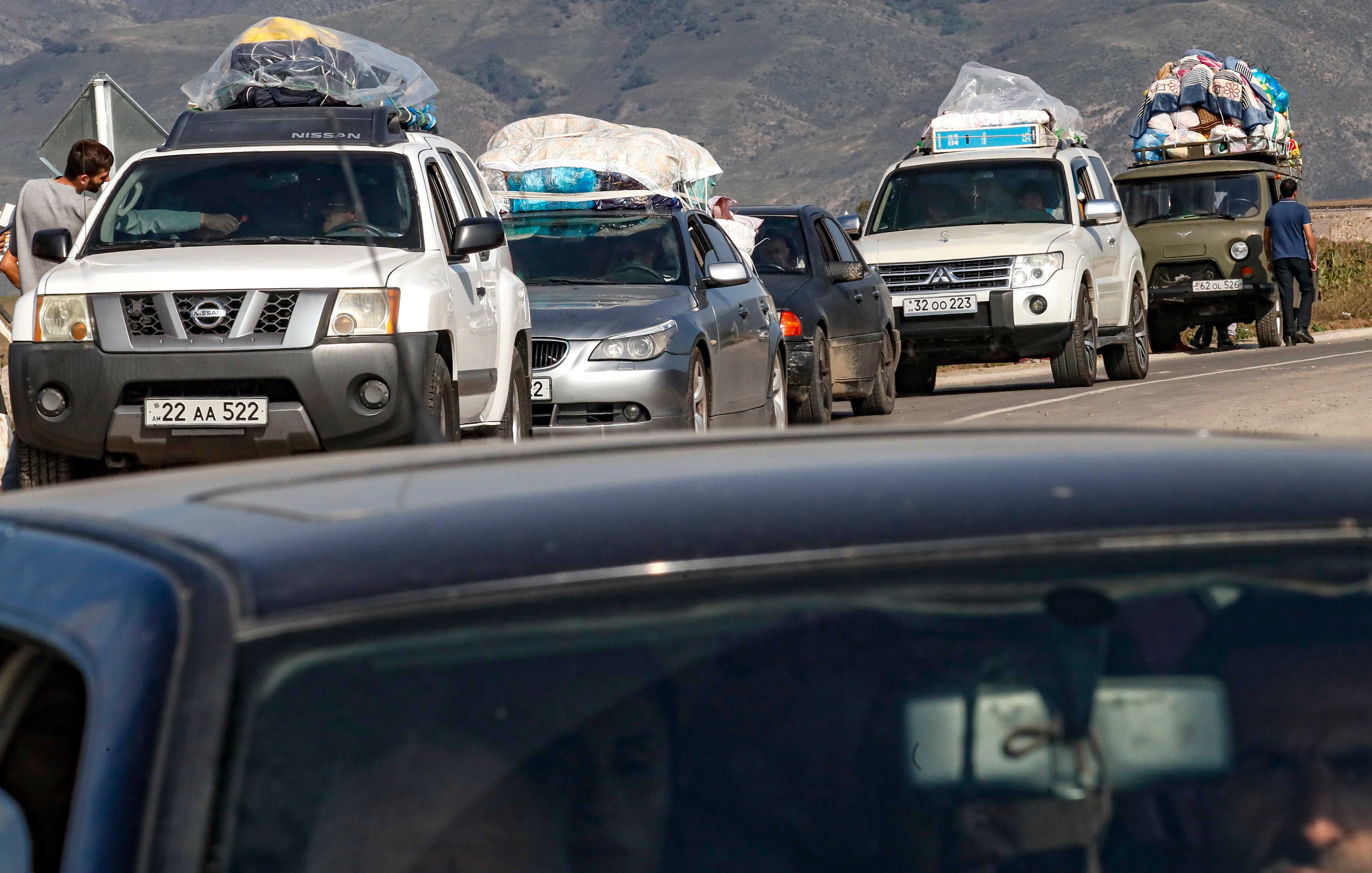 Ethnic Armenians fleeing Nagorno-Karabakh region drive near the village of Kornidzor