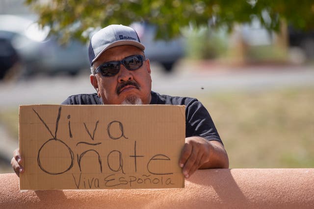 <p>An onlooker holds a “Viva Oñate” sign while demonstrators gather in front of the Rio Arriba County Complex to protest the placing of a statue of a Spanish conquistador </p>