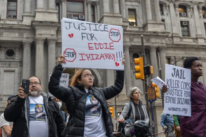 Maria Irizarry, a sister of the victim, holding up a sign to protest her brother’s killing