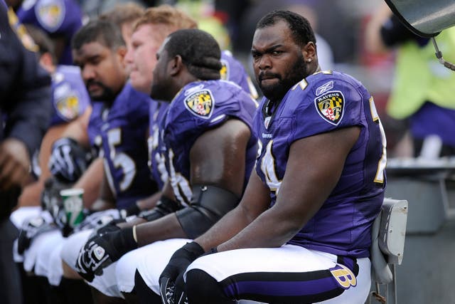 <p>Baltimore Ravens offensive tackle Michael Oher sits on the beach during the first half of an NFL football game against the Buffalo Bills in 2010 </p>