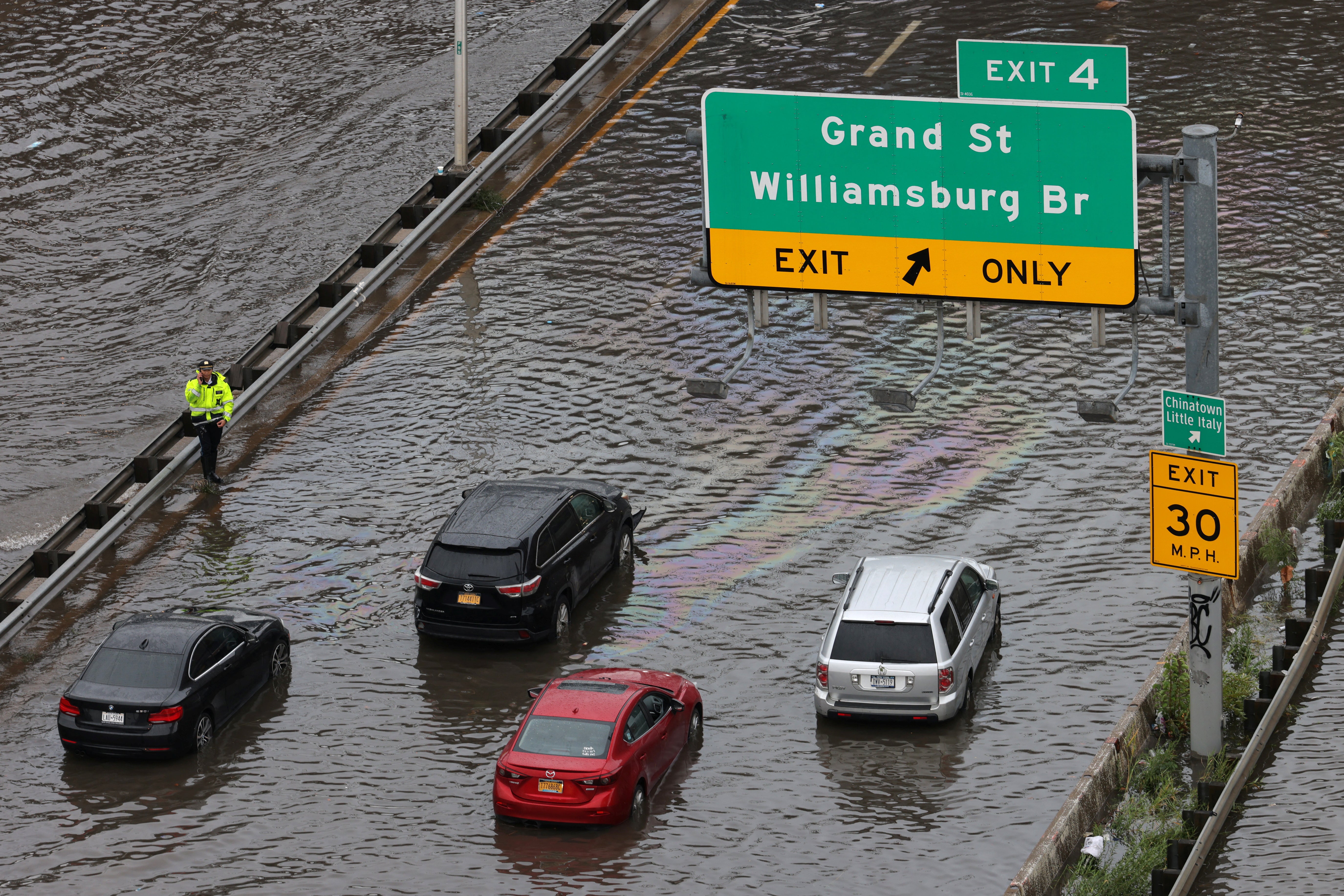 A police officer assists motorists stuck on a flooded street near the Williamsburg Bridge, in New York City on September 29, 2023