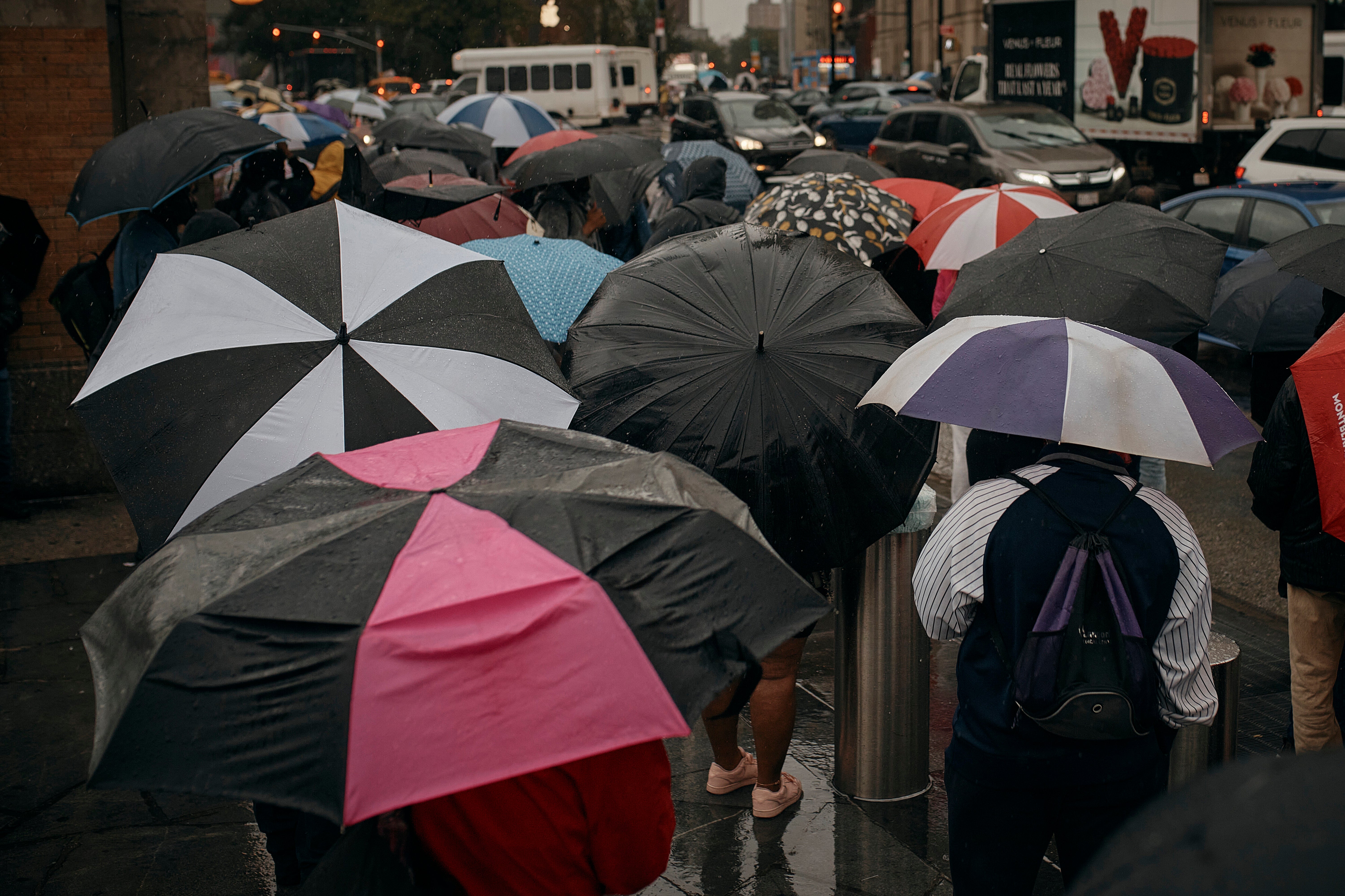 People wait for the bus as trains get cancelled due to flooding from heavy rains. The governor specifically thanked bus drivers on Saturday for helping to keep the city moving