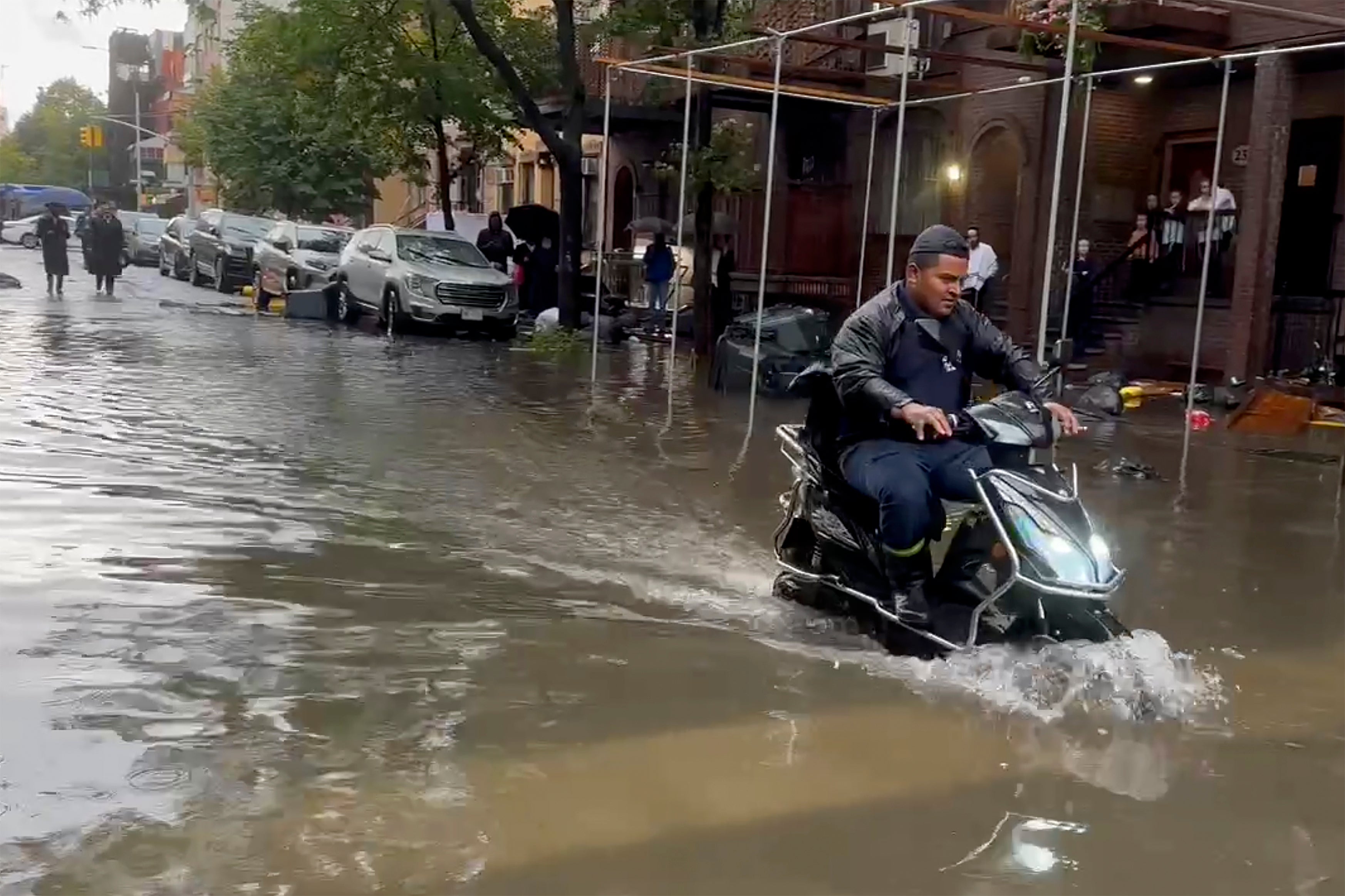 A man drives a scooter through flood waters last Friday in Brooklyn, New York