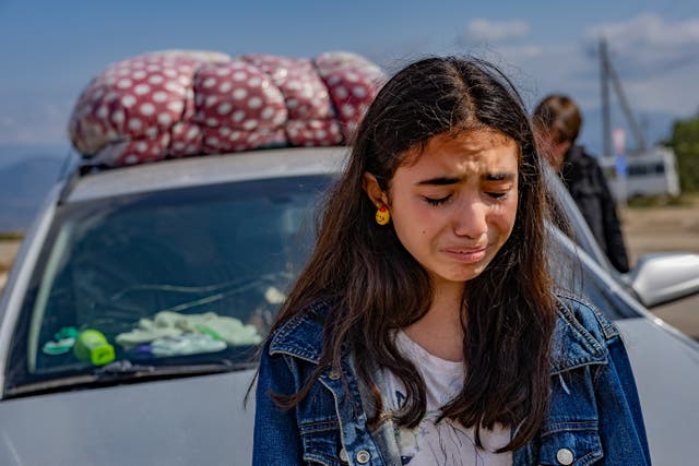 <p>A teenager from Nagorno-Karabakh cries as she crosses the border to Armenia</p>
