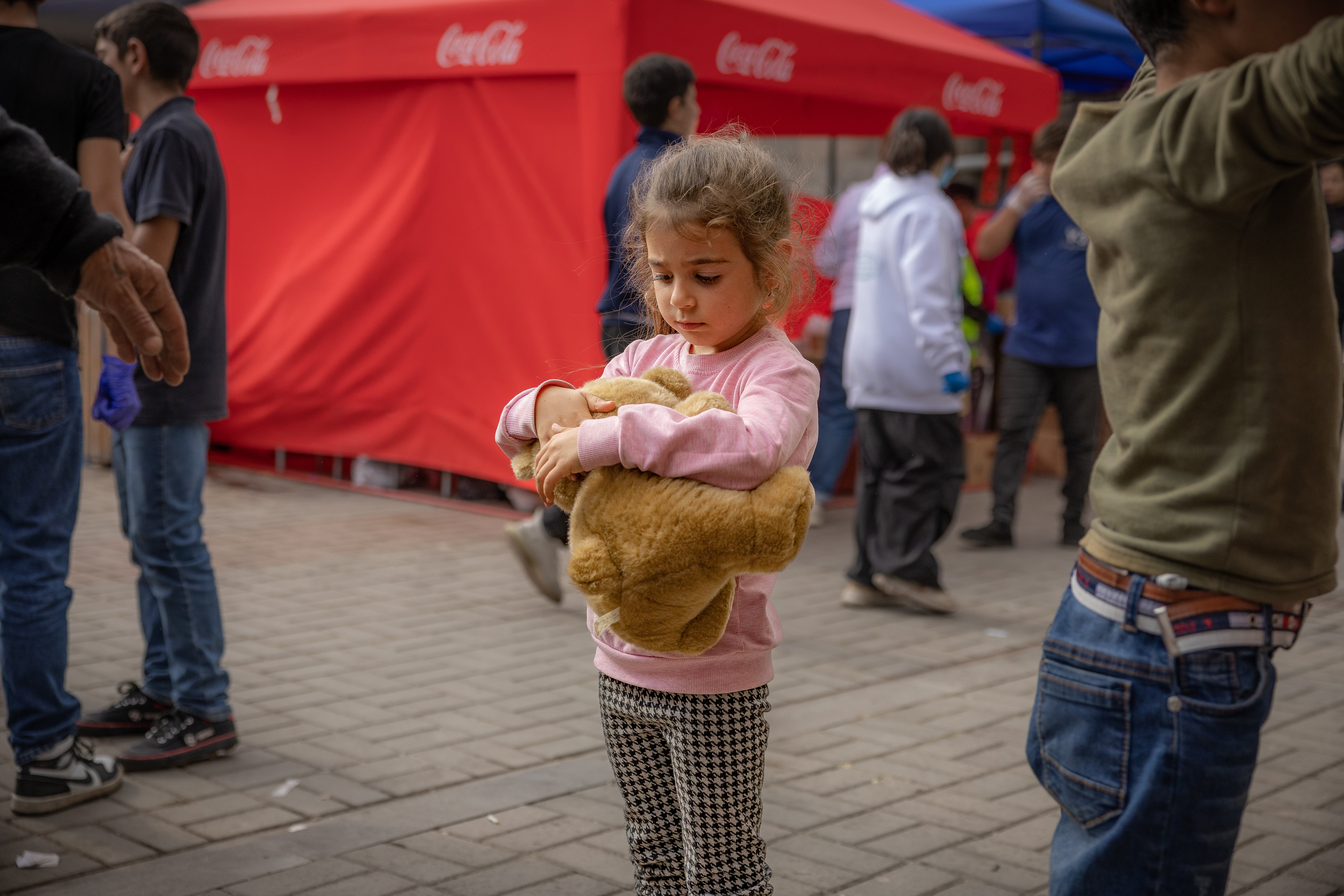 A refugee cuddles a teddy after arriving from a two day journey to Goris in Armenia