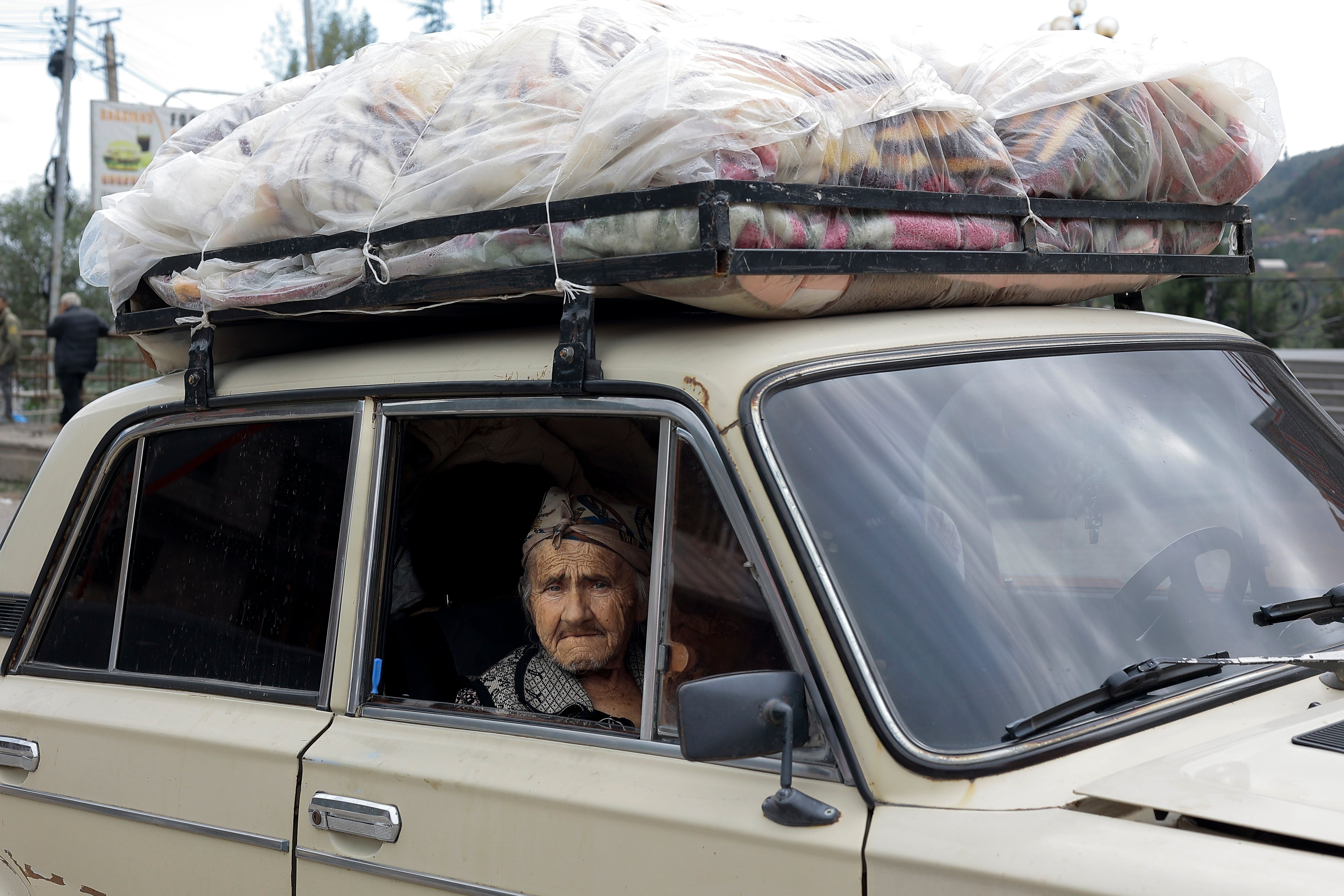 An ethnic Armenian woman from Nagorno-Karabakh sits inside an old Soviet-style car as she arrives in Goris, in Syunik region, Armenia