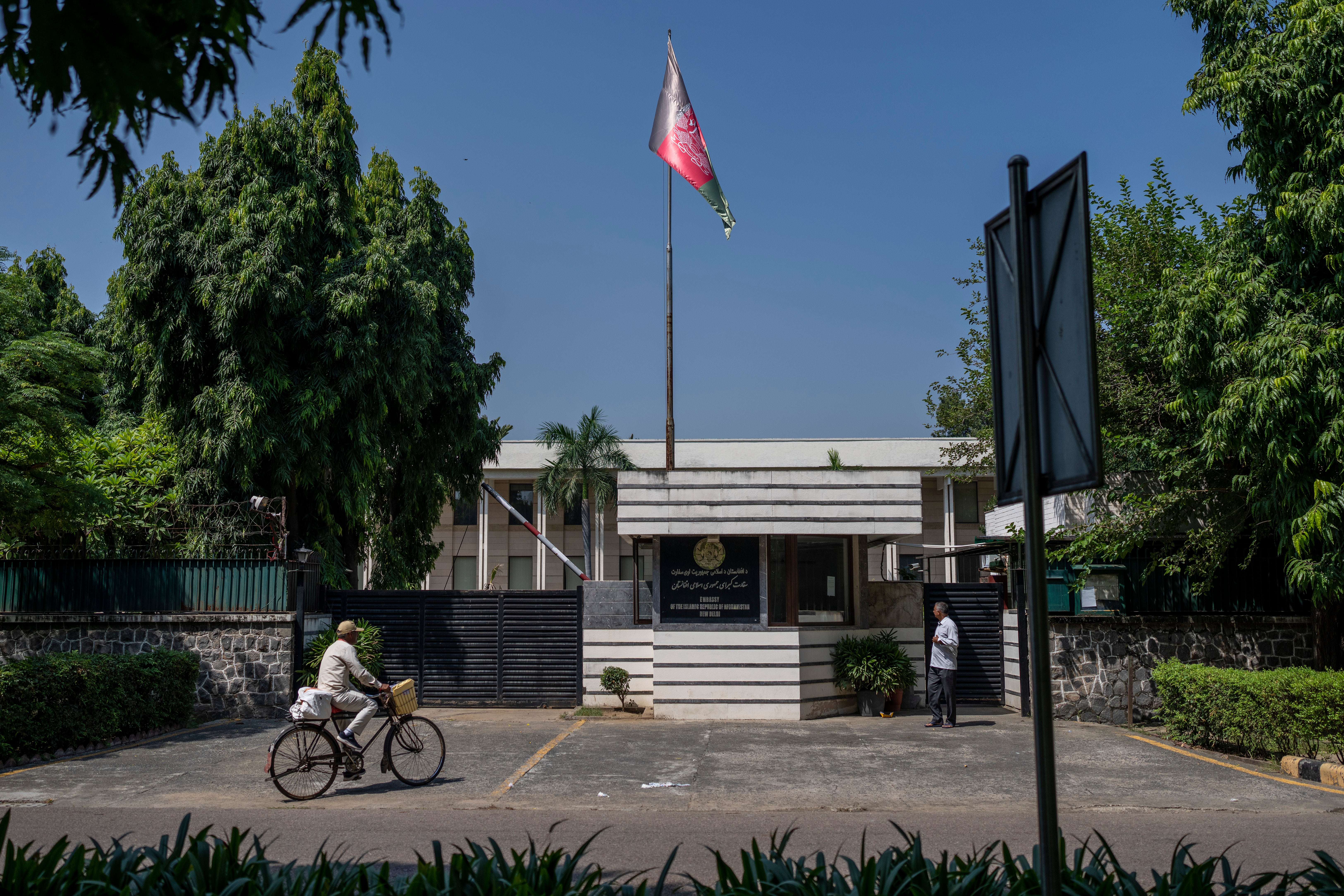 A cyclist pedals past the Afghan Embassy in New Delhi, India