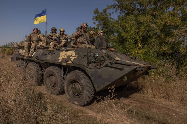 <p>Ukrainian members ride on top of an armoured personnel carrier as they take part in a military training in the Donetsk region</p>
