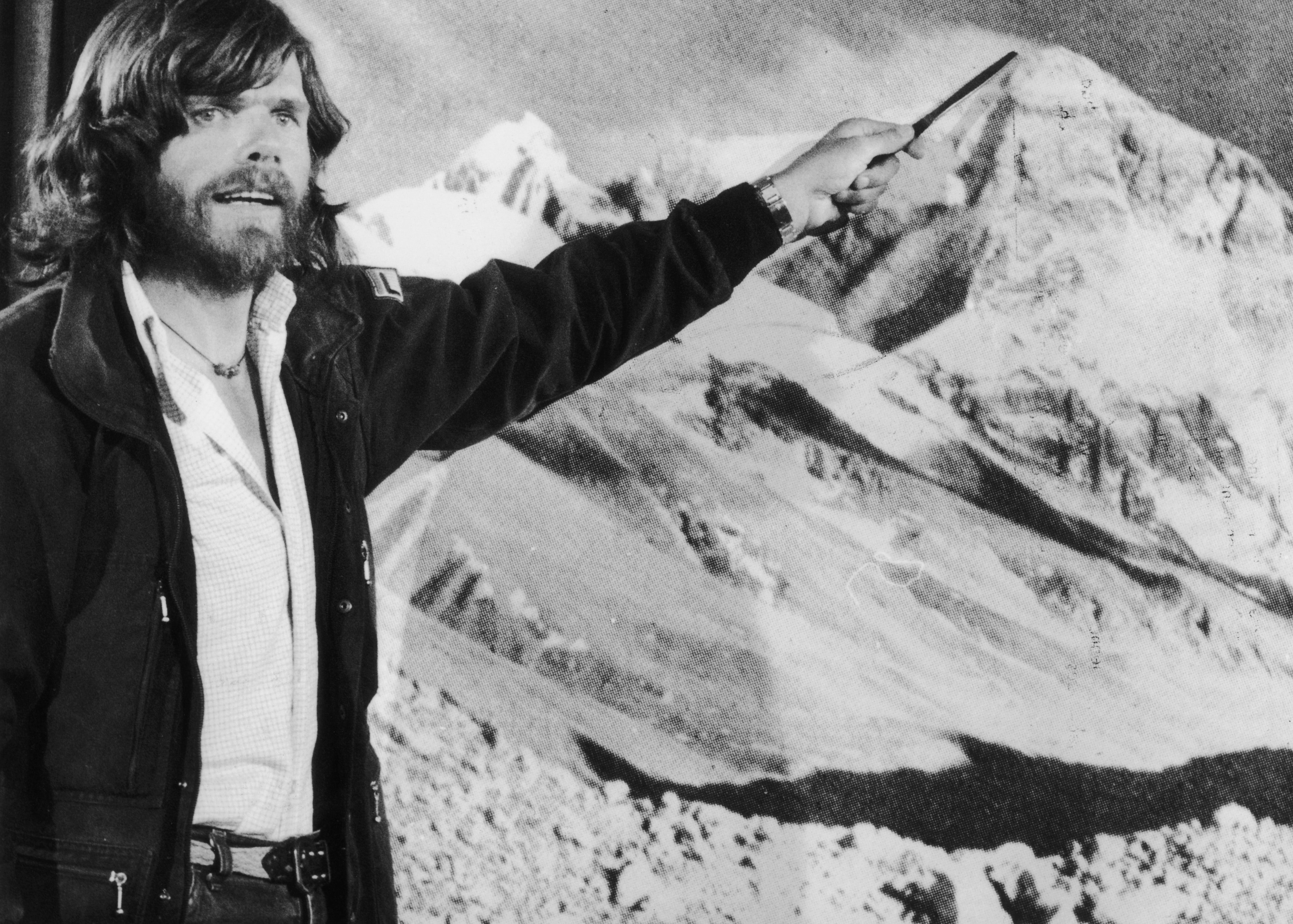 Messner points to a photograph of Mount Everest after his unprecedented solo ascent without supplementary oxygen, in 1980