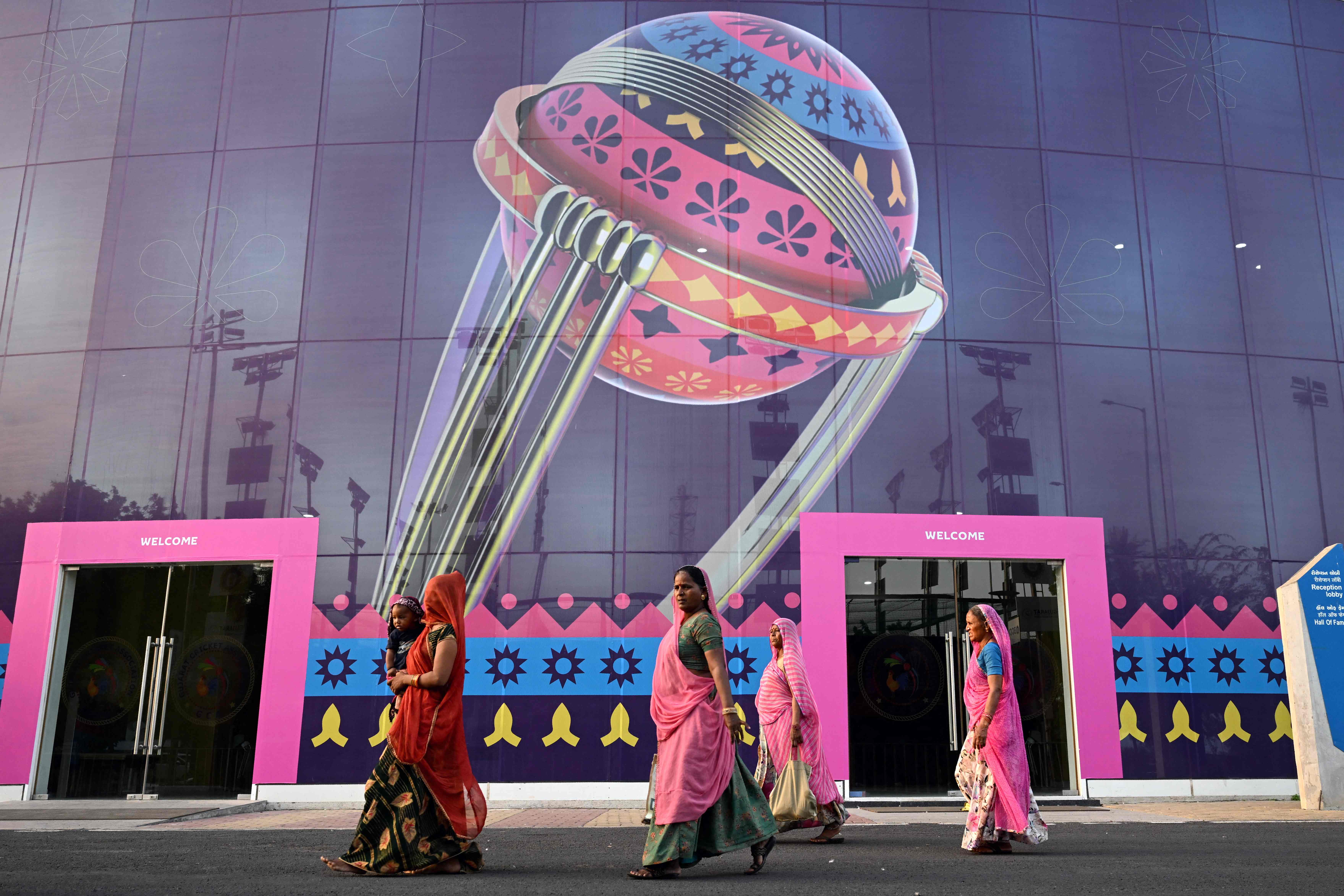 Women along with a child walk inside the complex of the Narendra Modi Stadium ahead of the 2023 ICC men's cricket World Cup, in Ahmedabad on 2 October 2023