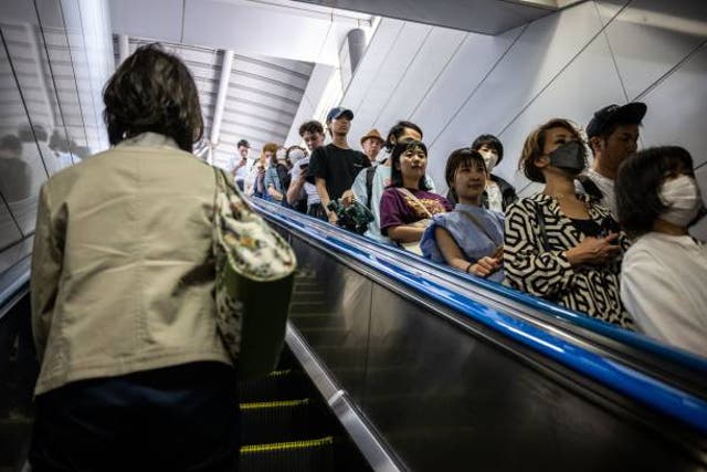 <p>File photo: People ride on an escalator at Shinjuku station in Japan on 1 June 2023</p>