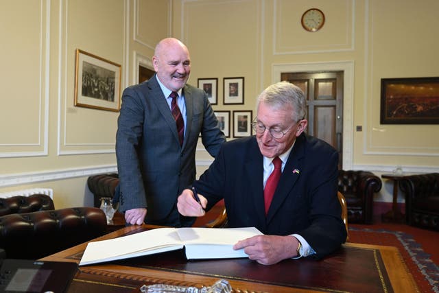 Shadow Northern Ireland secretary Hilary Benn signs the visitors’ book during his meeting with Speaker Alex Massey (Michael Cooper/NI Assembly/PA)