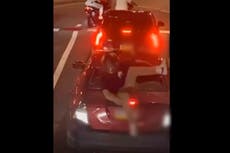 Hunt for dirt bike suspect filmed kicking through car window with children inside in road rage fight