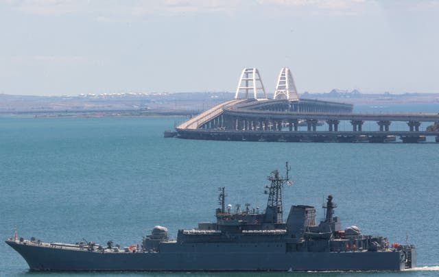 <p>A Russian warship sailing near the Kerch bridge, linking the Russian mainland to Crimea</p>