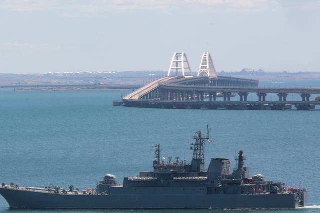 <p>A Russian warship sailing near the Kerch bridge, linking the Russian mainland to Crimea</p>