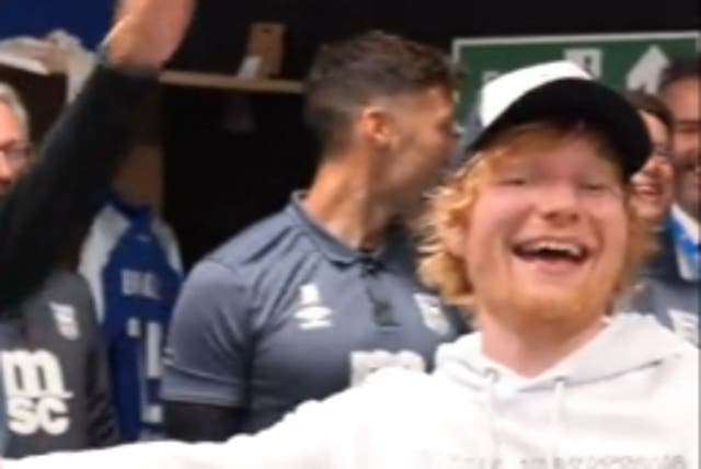 <p>Ed Sheeran sings with Ipswich Town players following their win over Hull</p>