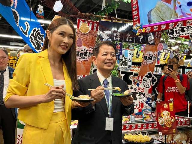 <p>Japanese agriculture minister Ichiro Miyashita (right) and Malaysian celebrity Amber Chia attend an event at Japanese store, Don Don Donki in Kuala Lumpur on 4 October 2023 to promote the safety and deliciousness of Japanese scallops to shoppers</p>