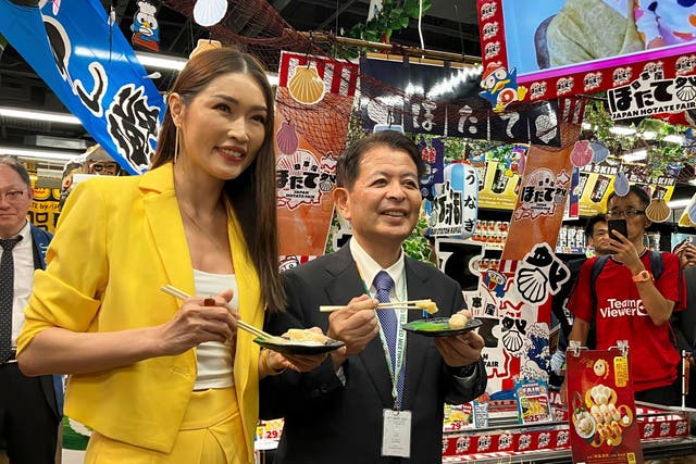 <p>Japanese agriculture minister Ichiro Miyashita (right) and Malaysian celebrity Amber Chia attend an event at Japanese store, Don Don Donki in Kuala Lumpur on 4 October 2023 to promote the safety and deliciousness of Japanese scallops to shoppers</p>