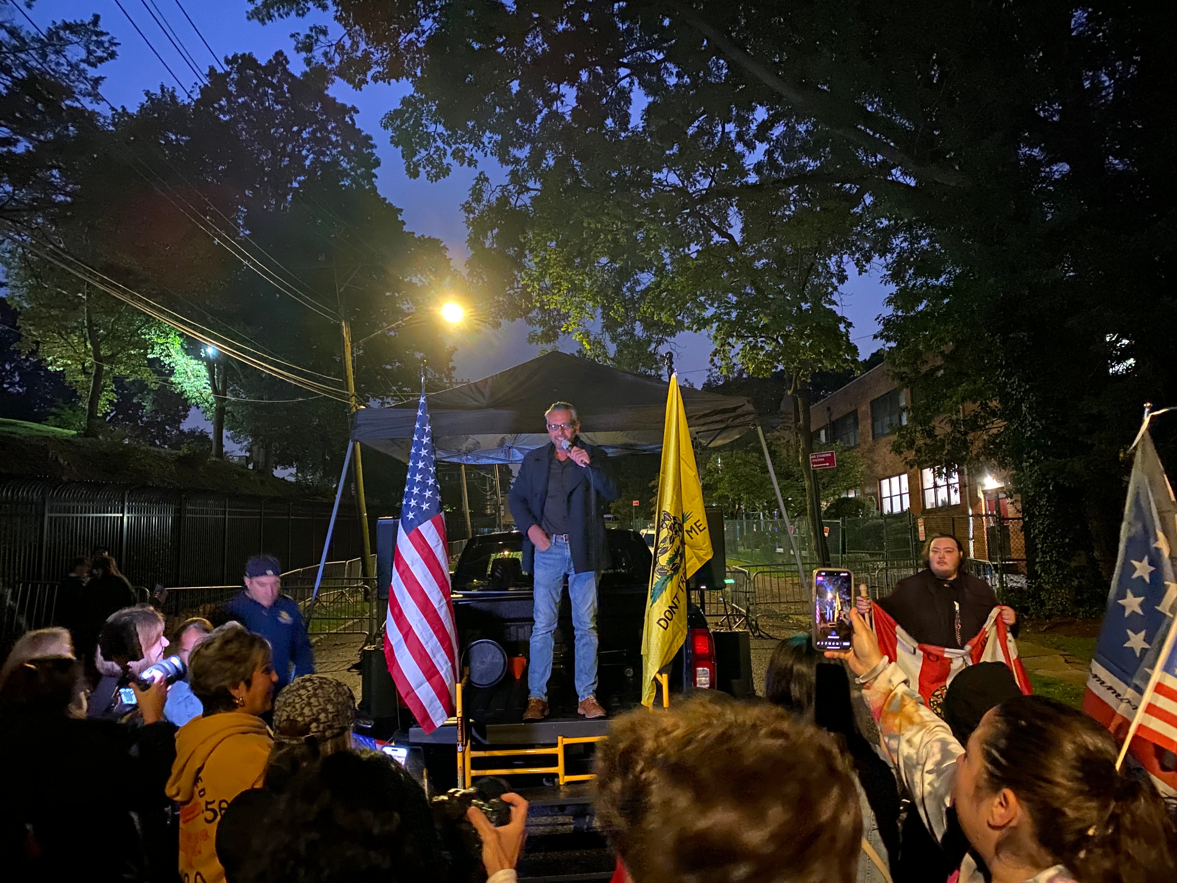 Scott LoBaido, an activist and artist who paints portraits of Donald Trump and American flags, addresses a protest outside of a migrant centre on Staten Island.