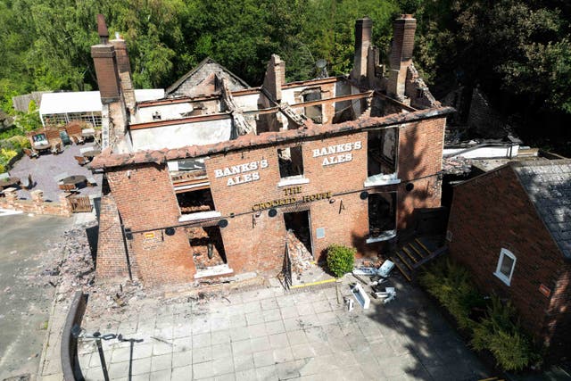 The burned remains of The Crooked House pub, which was later demolished (Jacob King/PA)