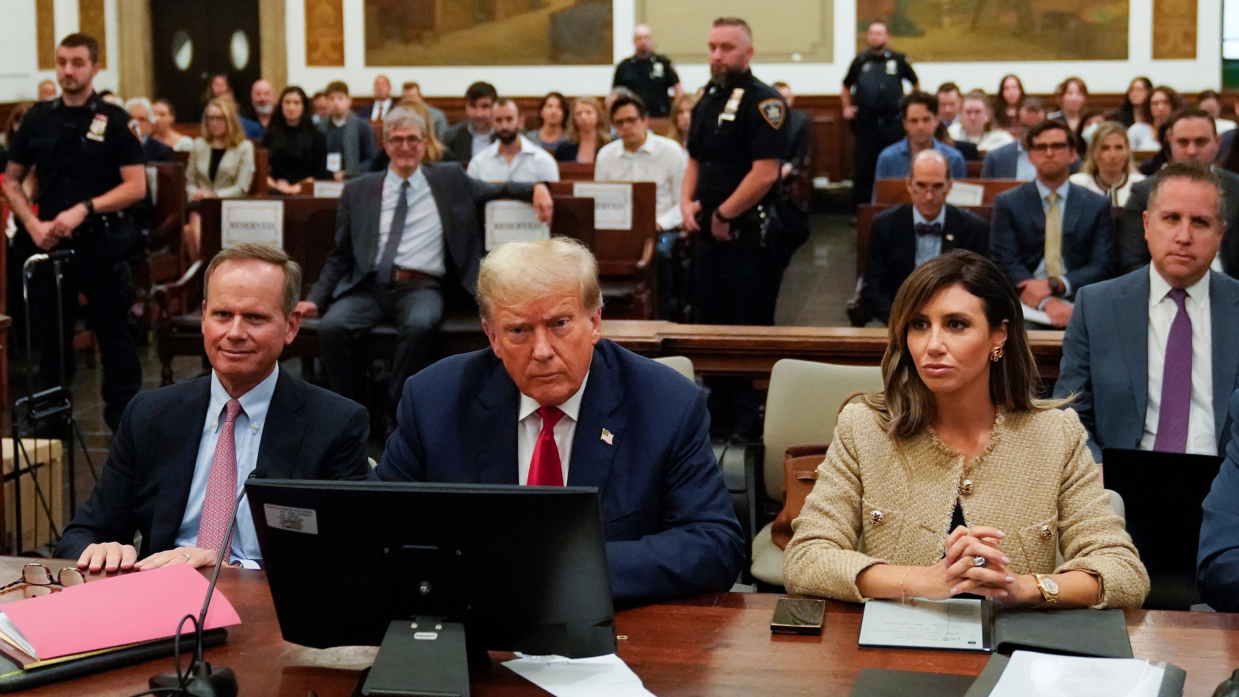 Former President Donald Trump, centre, sits in the courtroom with his legal team, including attorney Alina Habba (R) and Christopher Kise (L)