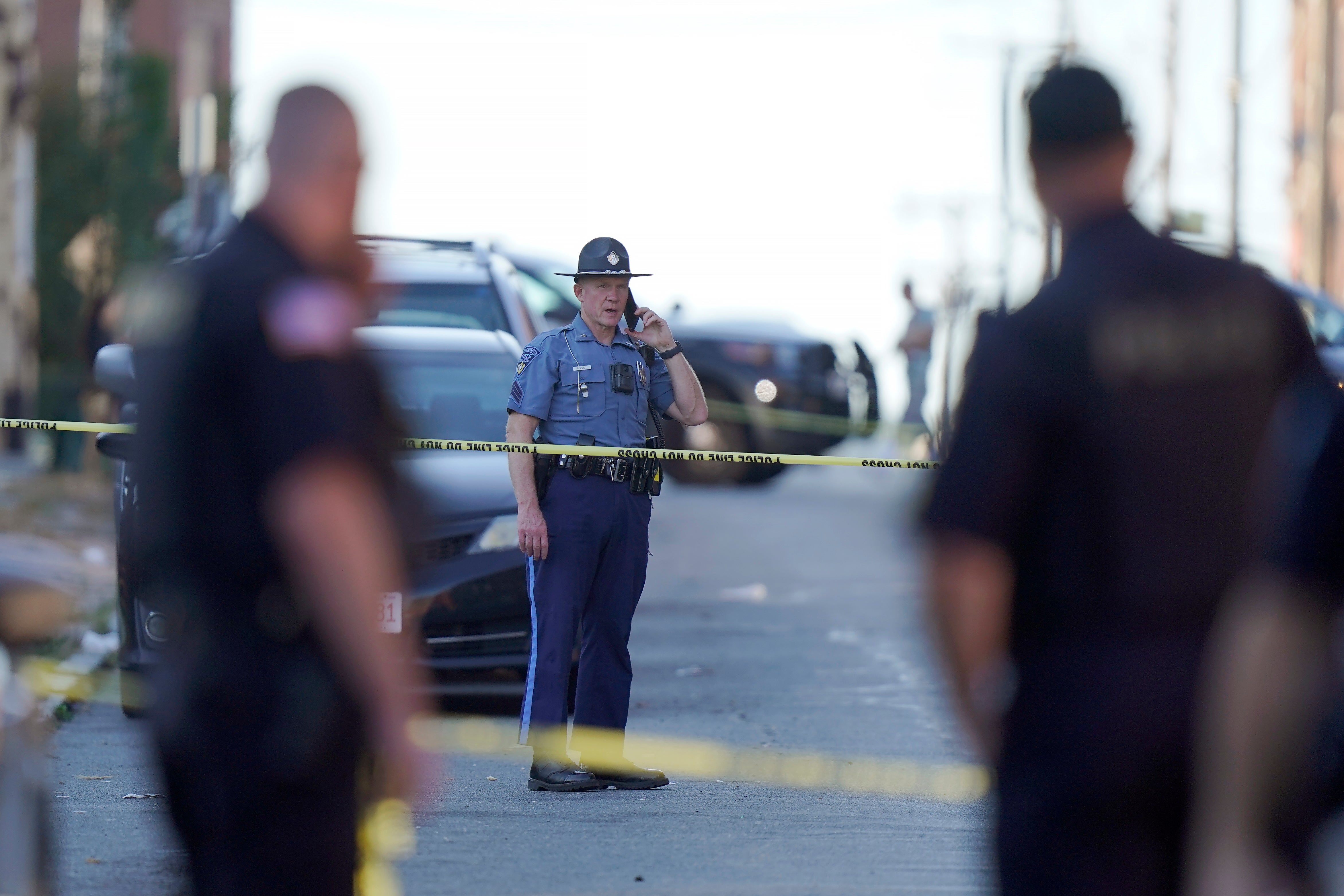 Members of law enforcement stand near police tape while investigating the scene where multiple people were shot, Wednesday, Oct. 4, 2023, in Holyoke, Mass.
