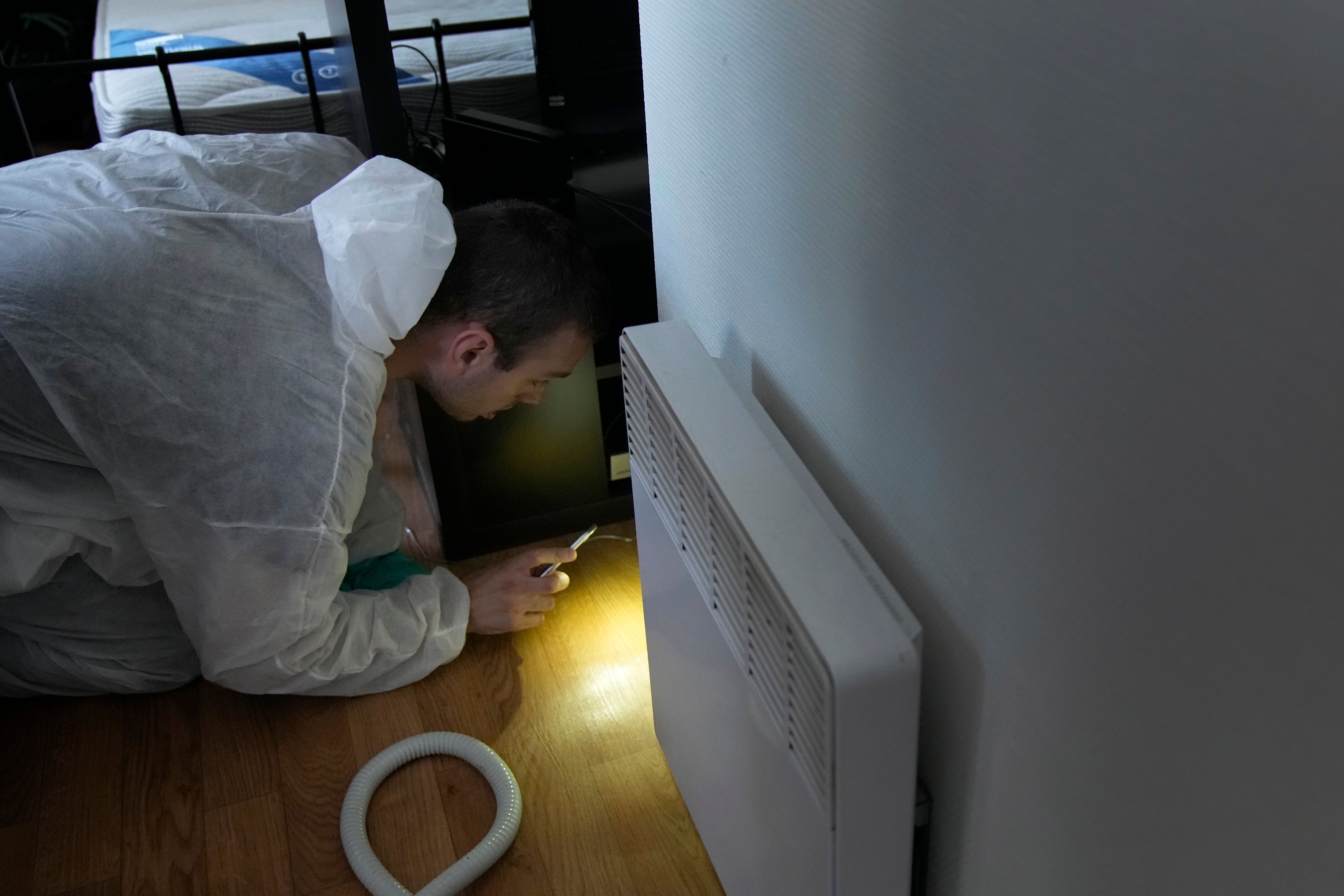 Pest control technician Lucas Pradalier looks for bedbugs in a Paris apartment