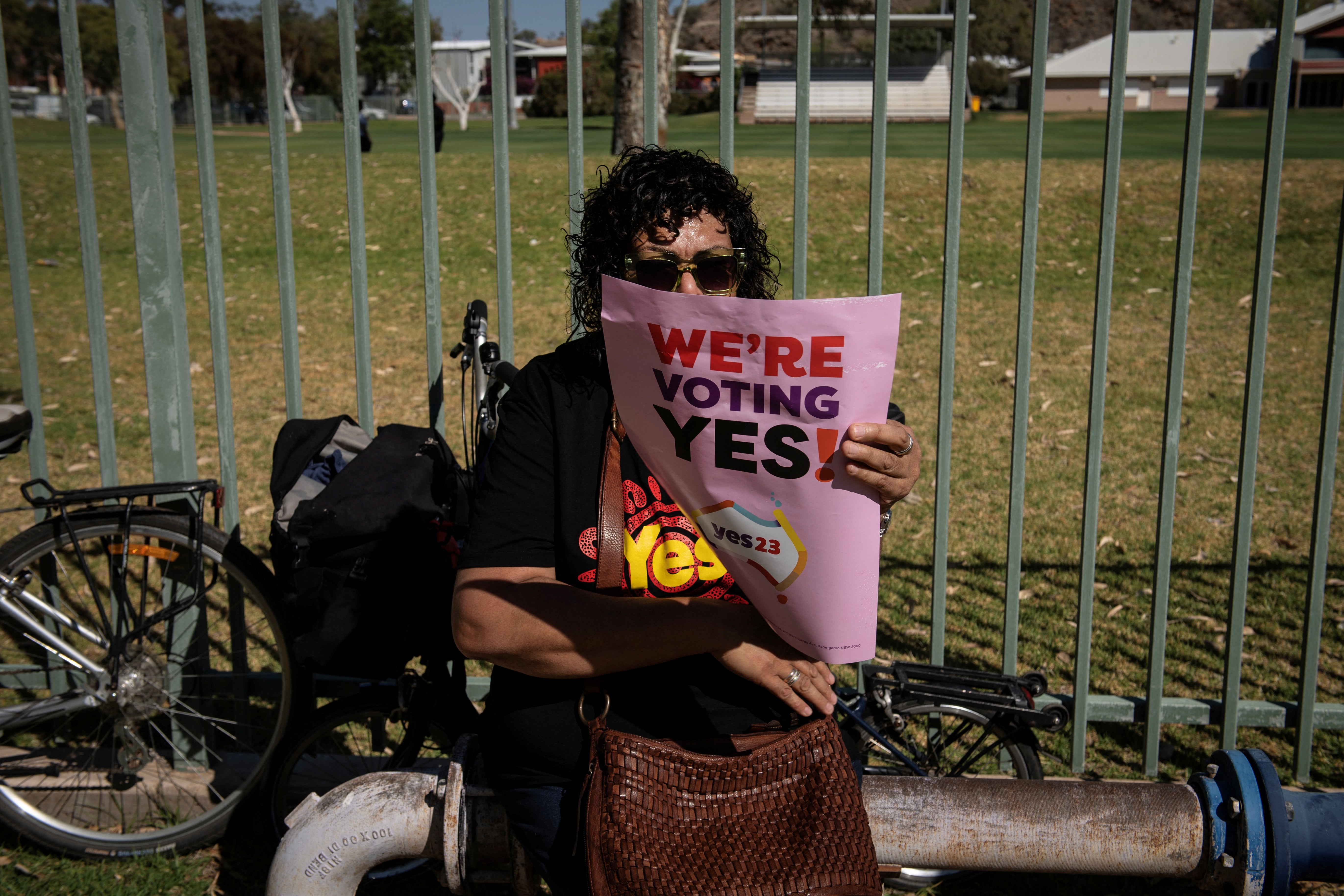 A woman holds up a sign supporting the Voice to Parliament at the Walk for Yes event in Alice Springs