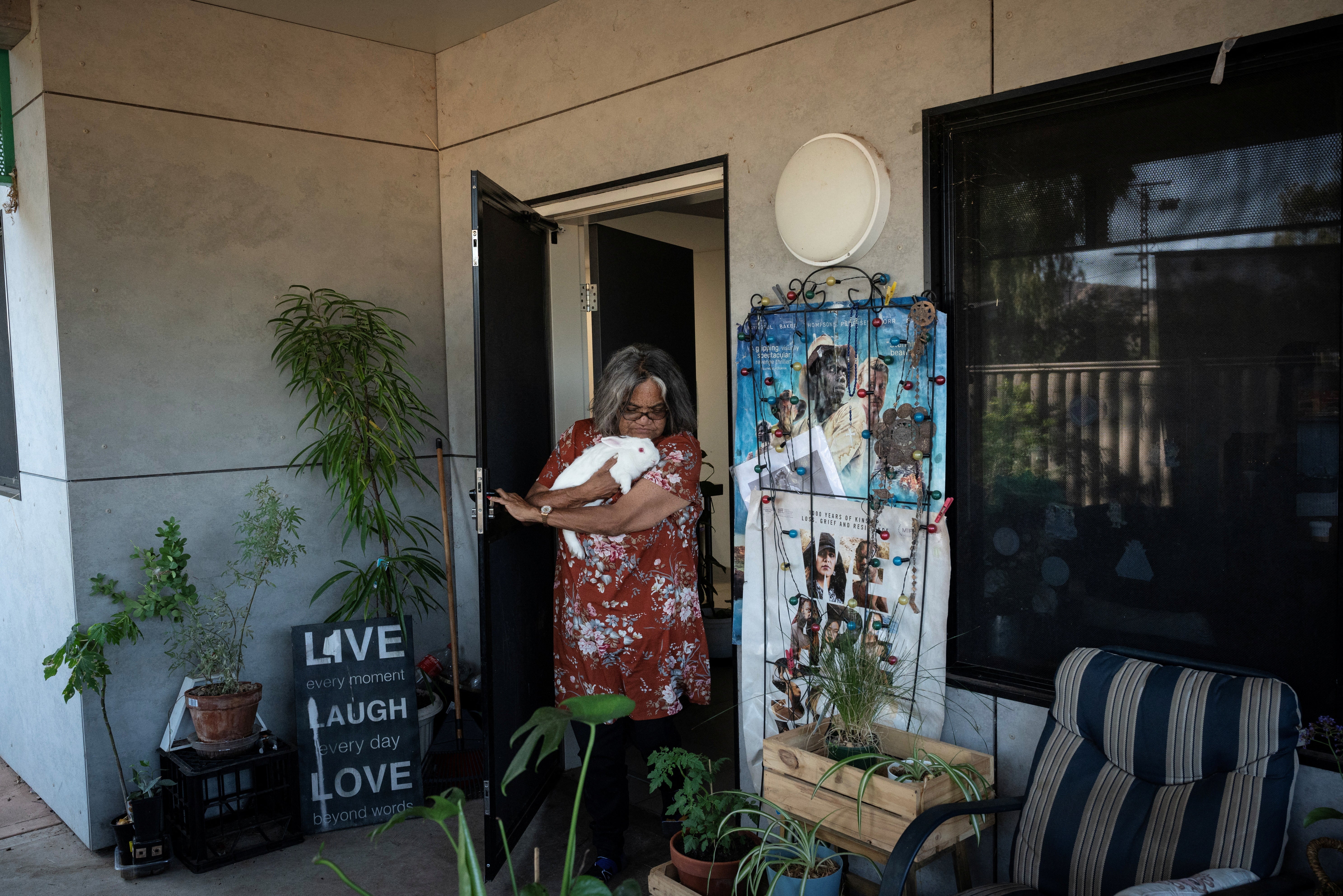 Artist Kathy Coulthard, who is Indigenous, walks onto the back porch of her home in Alice Springs