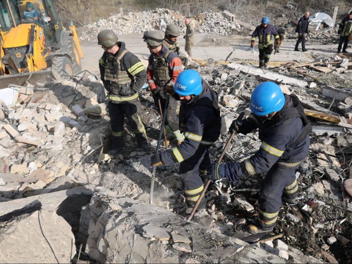 Rescues remove debris at a site of a Russian military strike, amid Russia’s attack on Ukraine, in the village of Hroza