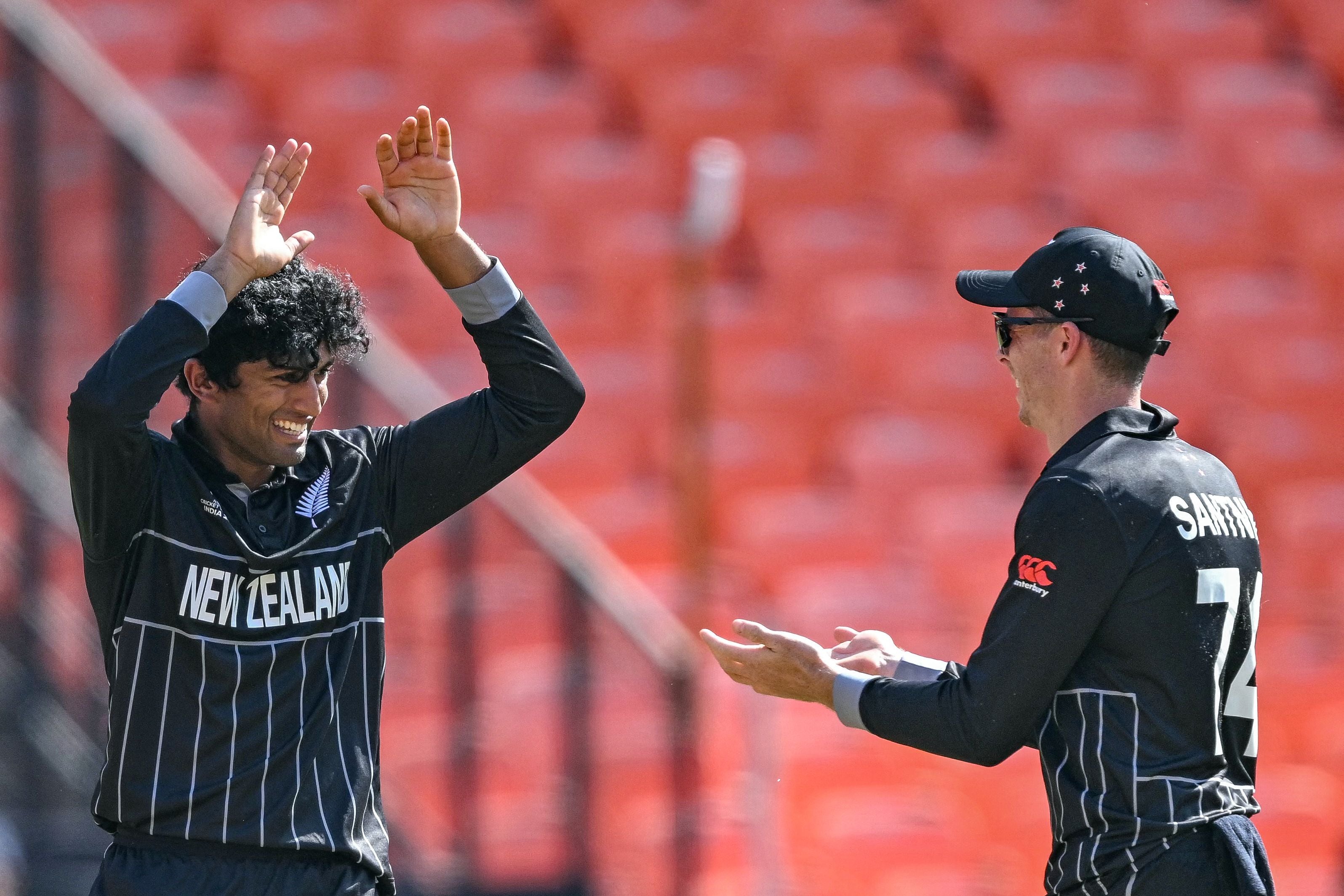 Rachin Ravindra celebrates with his teammate after taking the wicket of England’s Harry Brook during the 2023 ICC men’s cricket World Cup one-day international (ODI) match between England and New Zealand